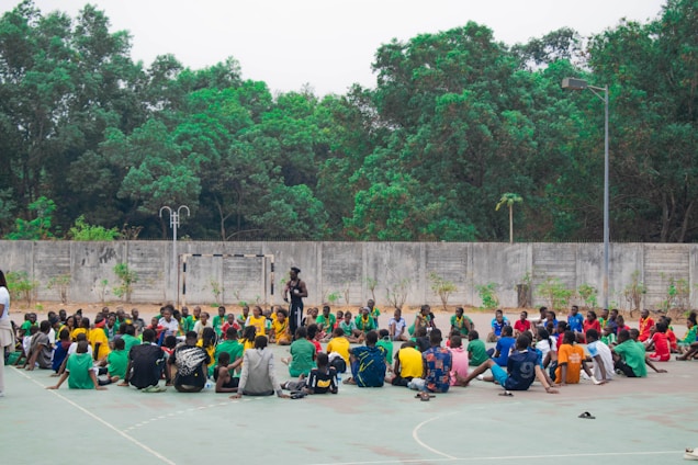 Group of people sitting in a circle outdoors.