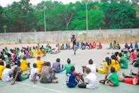 Man addresses group of people sitting in a circle.