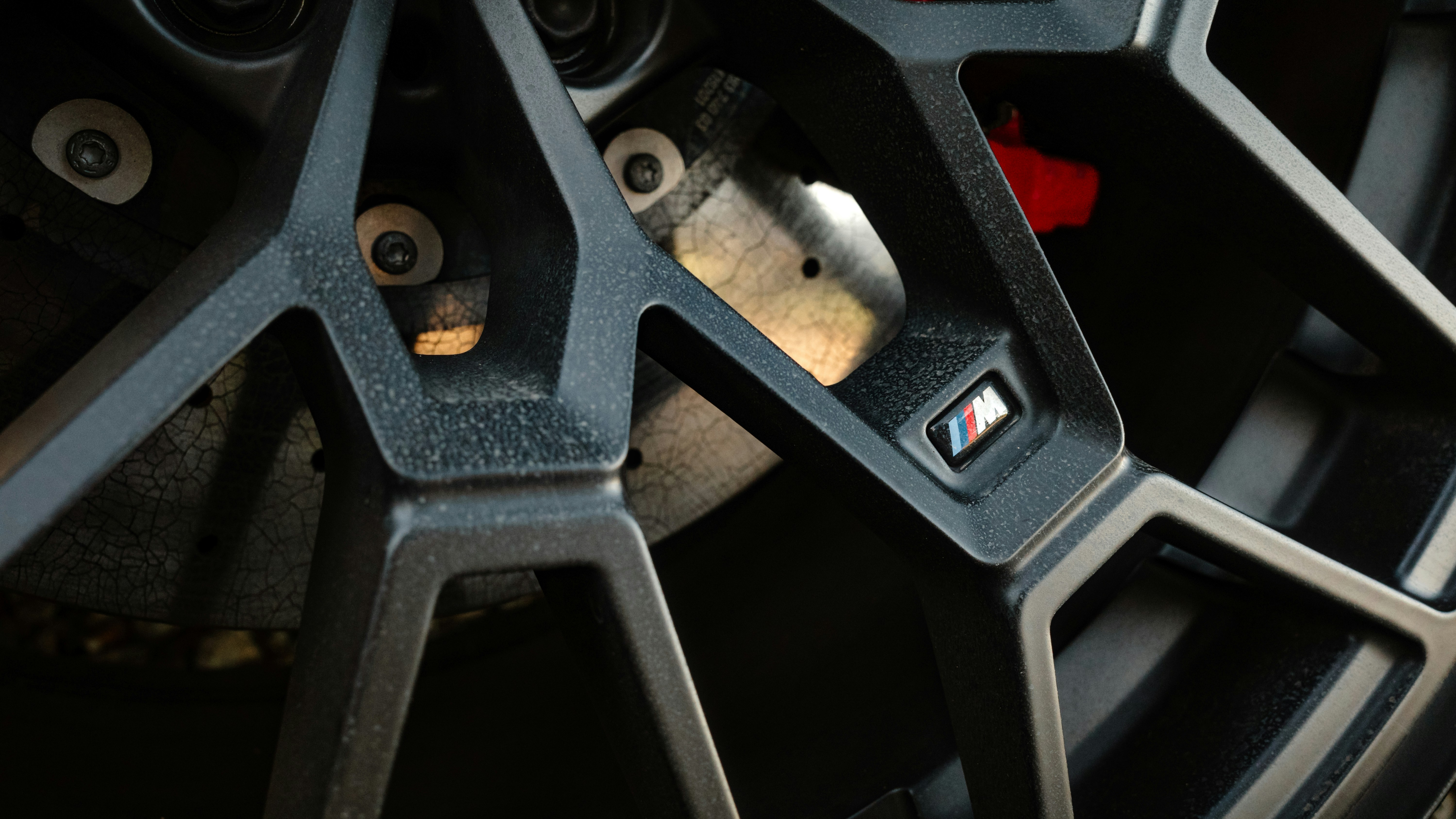 Technician inspecting an electric vehicle brake rotor and caliper on a lift