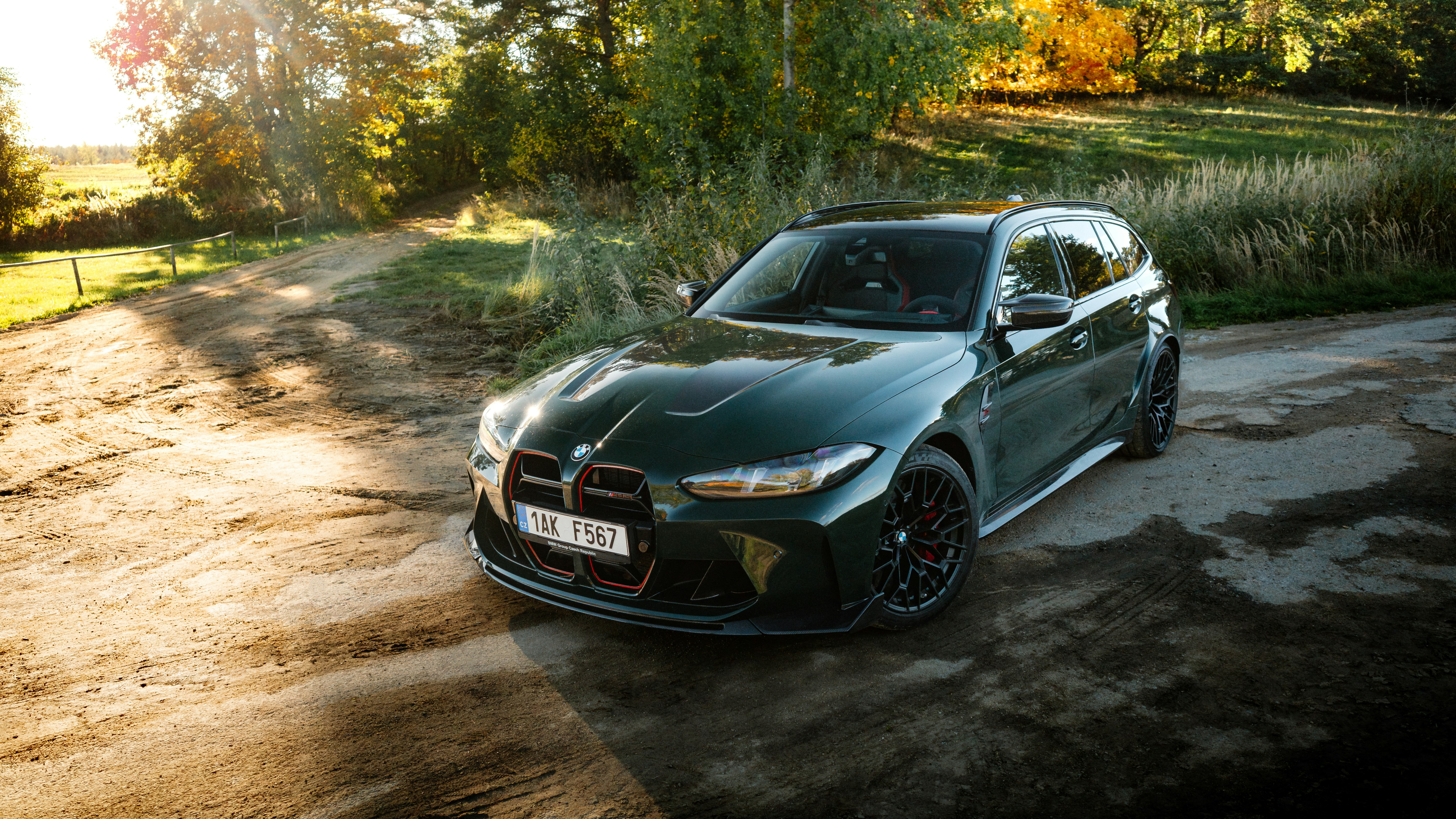 Dark green station wagon parked on a dirt road