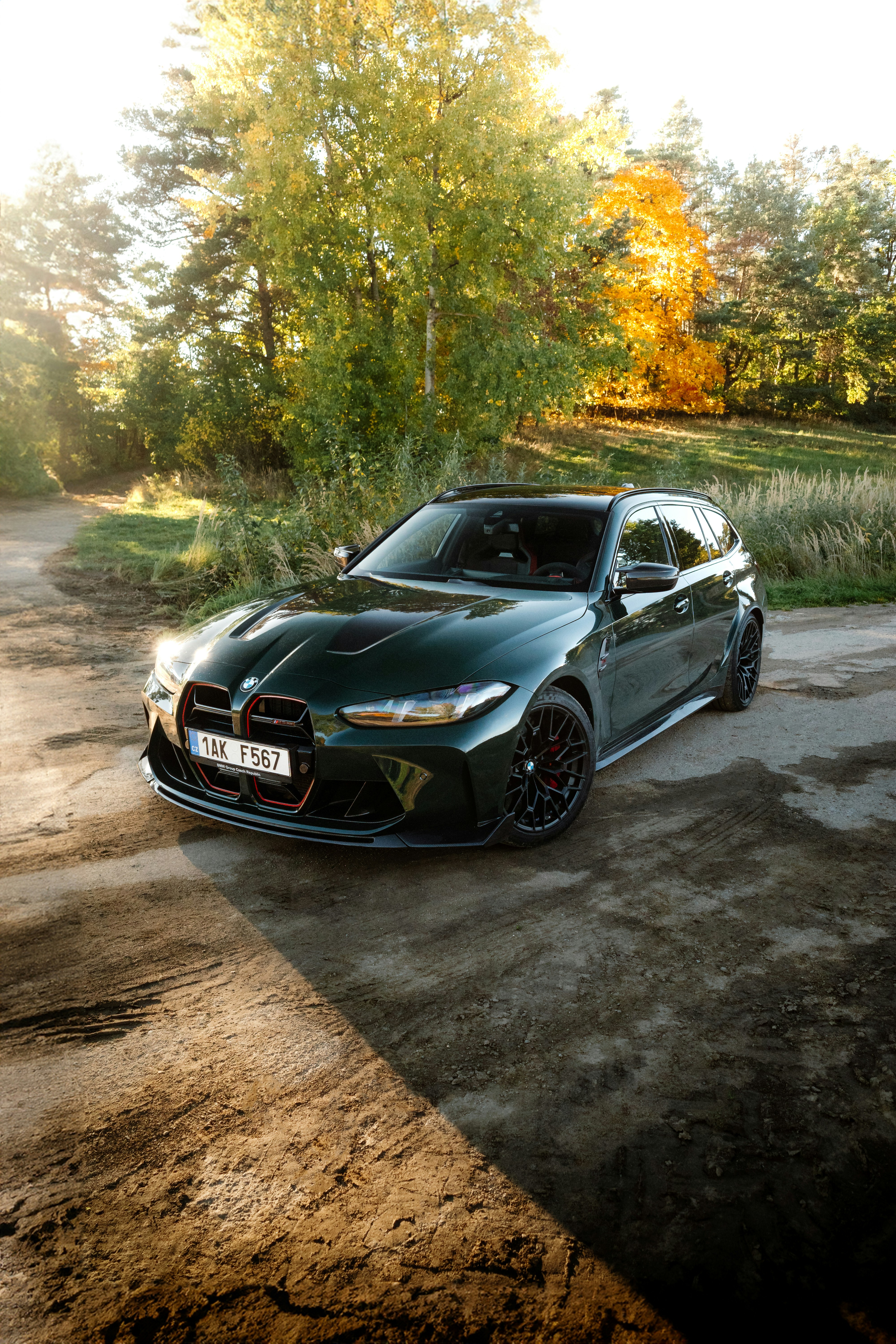 Dark green station wagon parked on dirt road