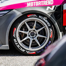 Close-up of a race car tire with kumho branding.