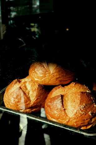 Three golden brown bread rolls stacked together