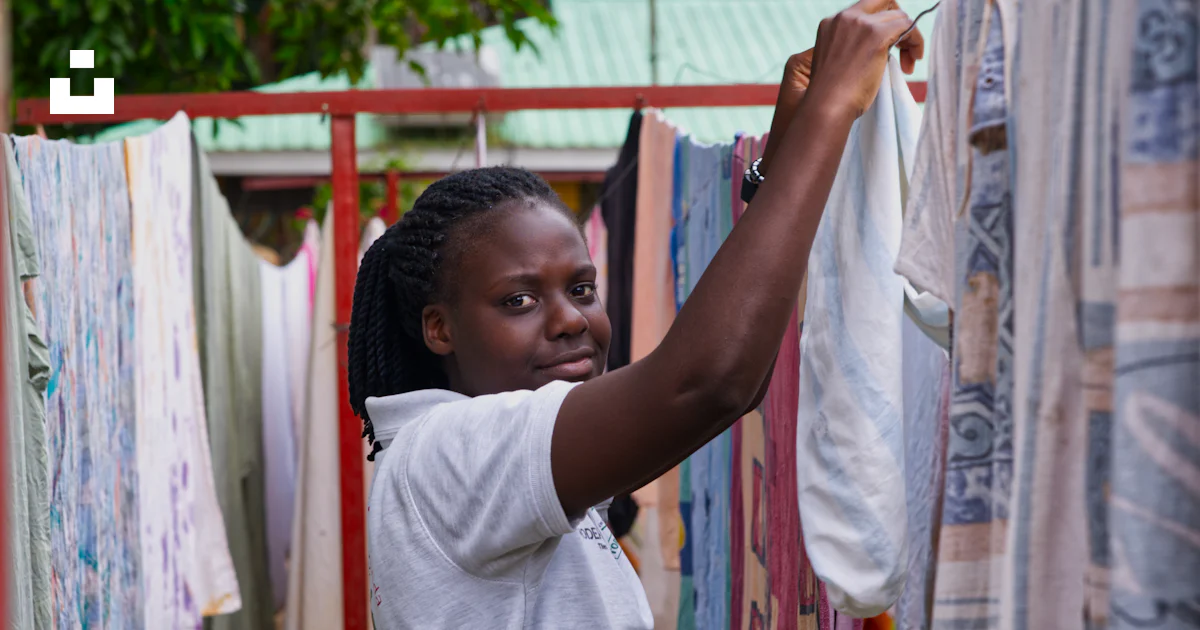 Photo Linge Une jeune femme étend du linge sur une corde à linge à l’extérieur ...