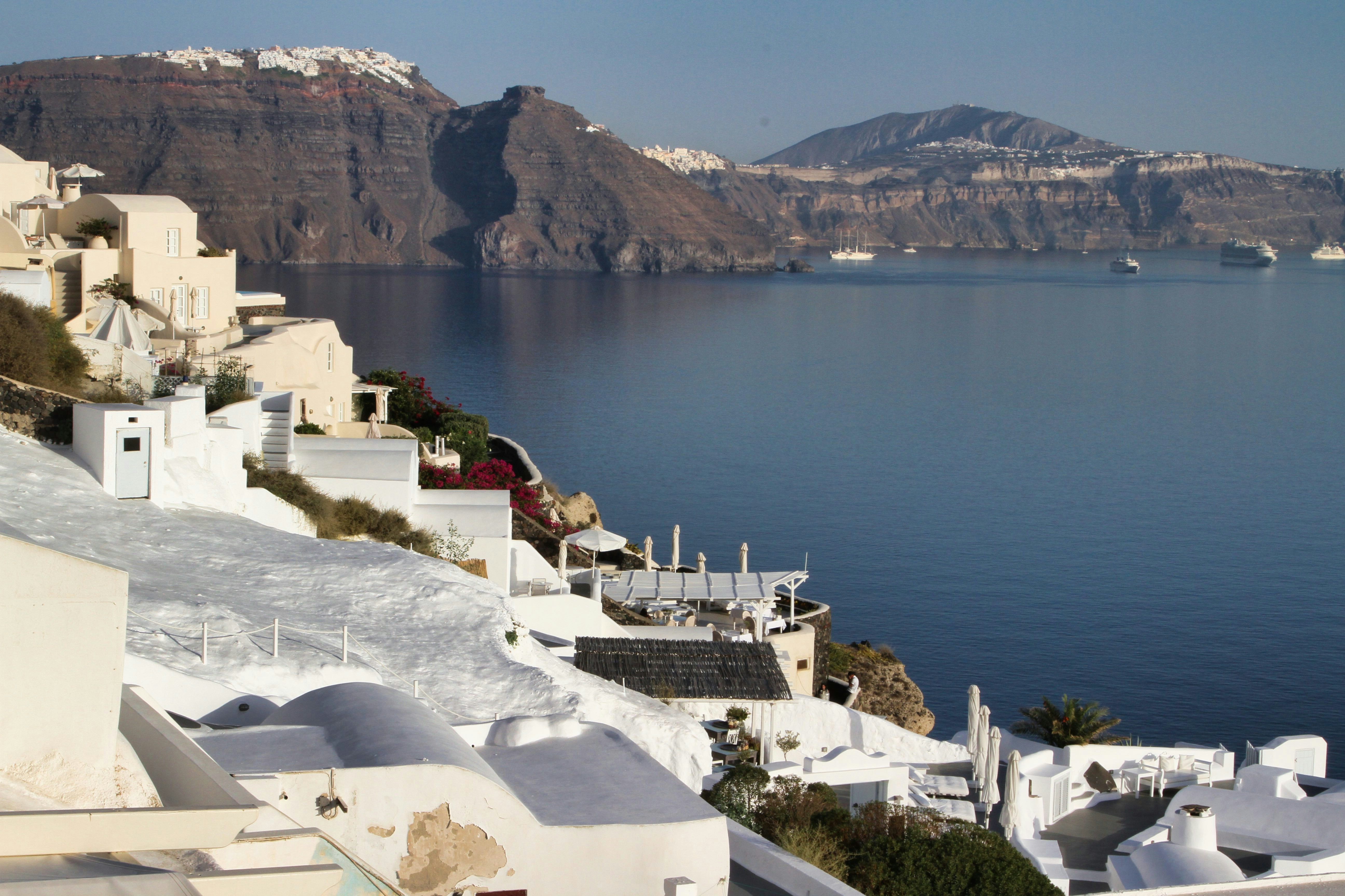 White buildings on a cliff overlooking the sea.