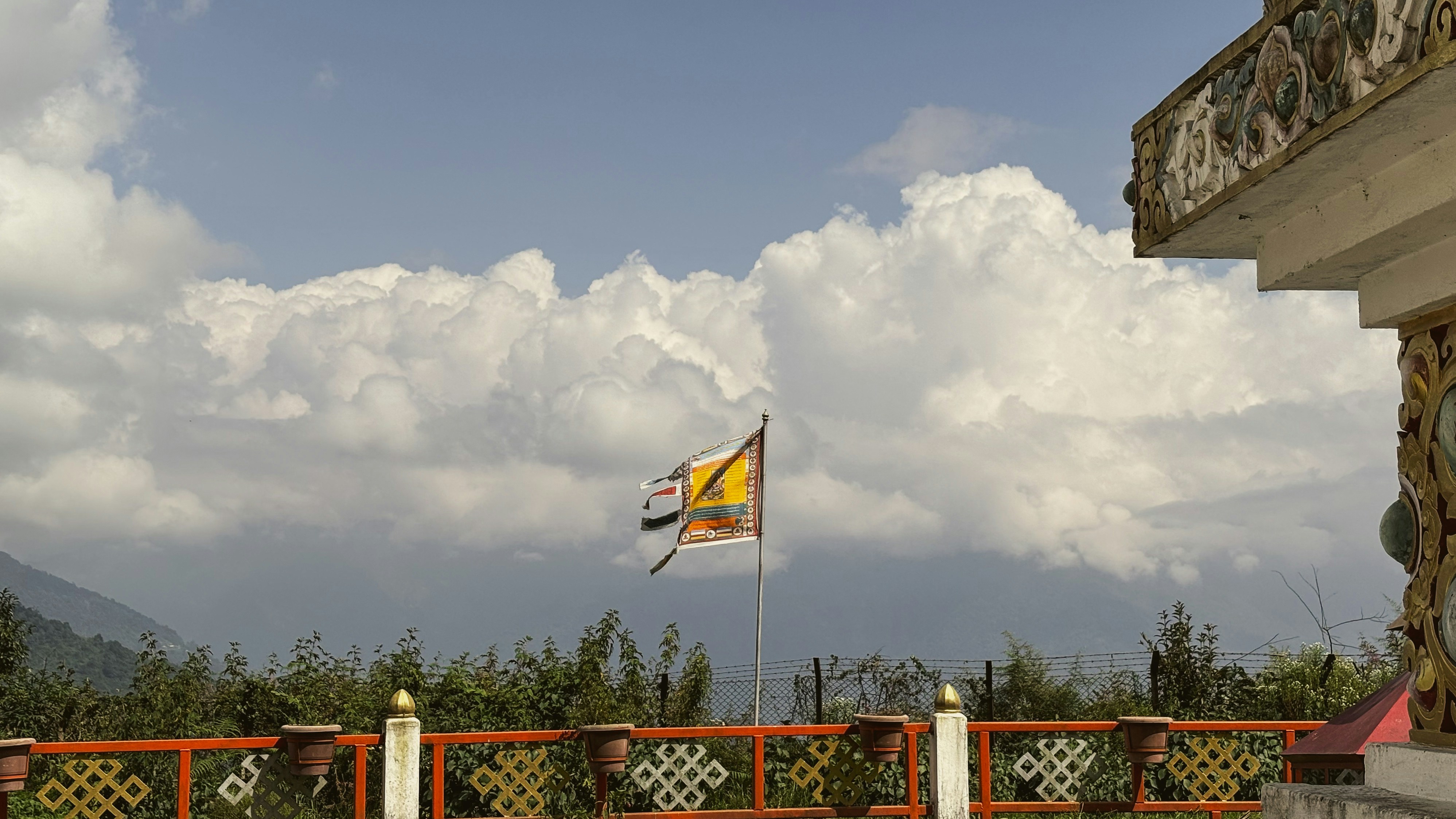 A flag flies against a cloudy sky