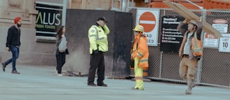 Construction workers carrying lumber and talking at site
