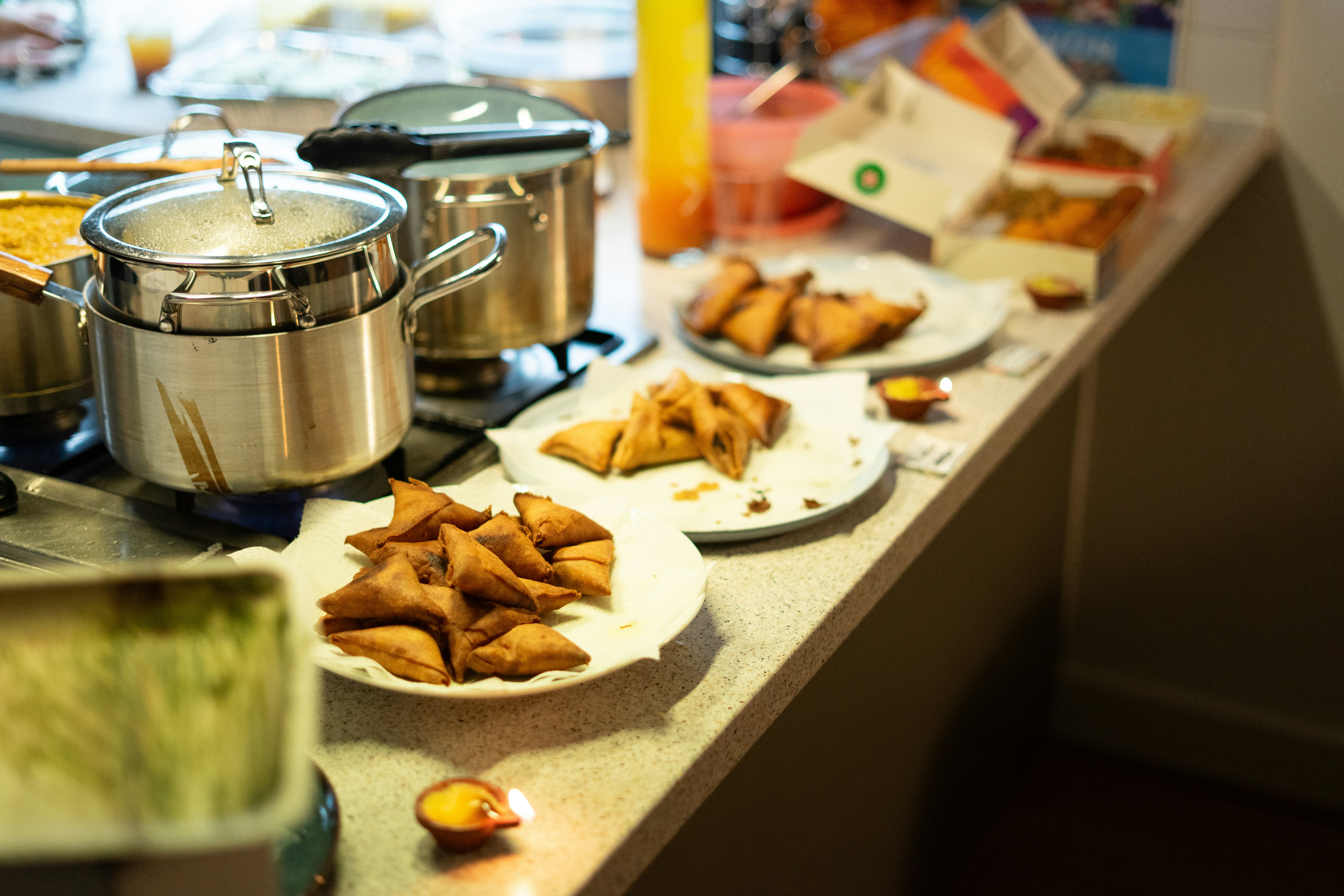 Samosas and food served on plates on a counter