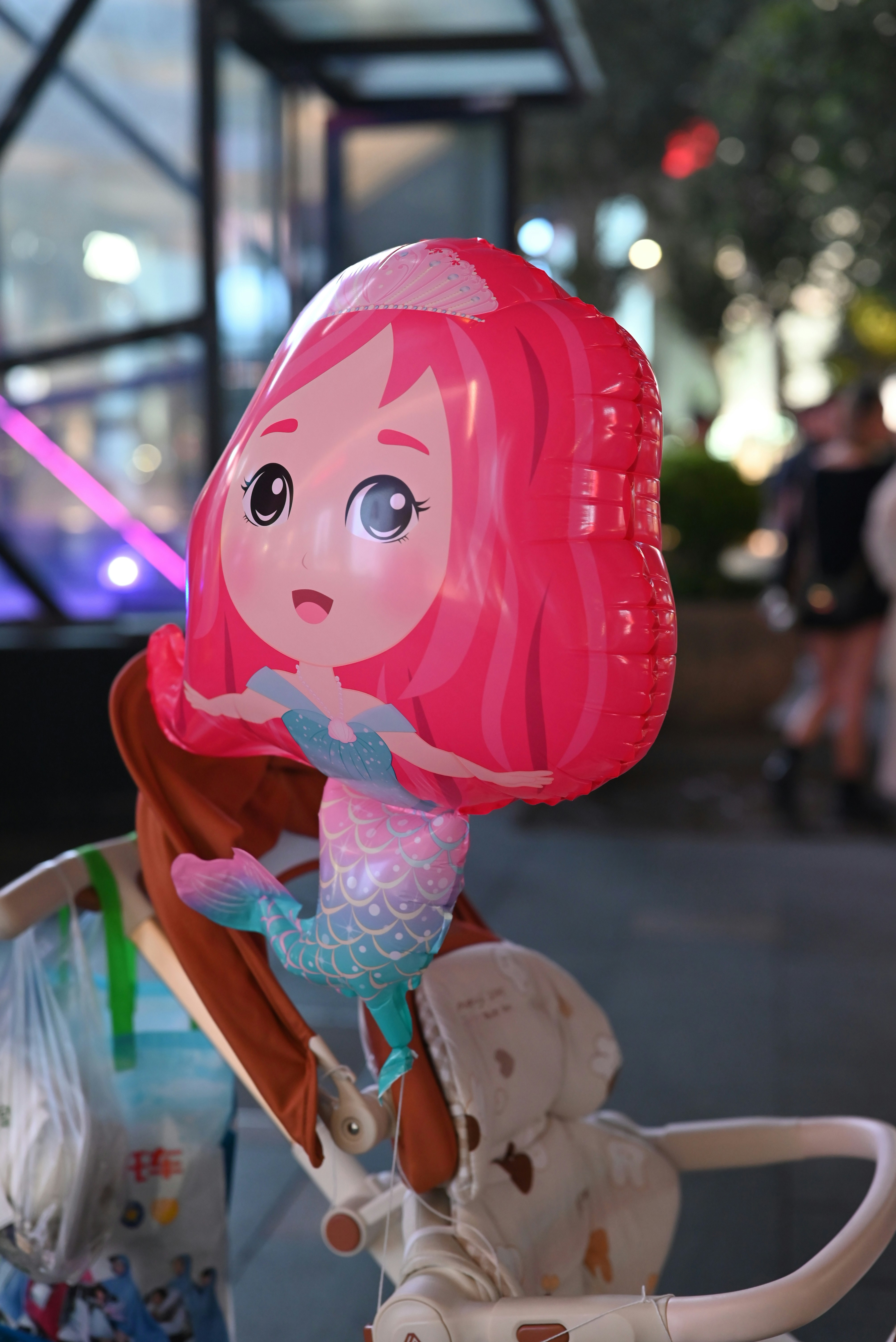 Ein rosa Meerjungfrauen-Ballon auf einem Kinderwagen