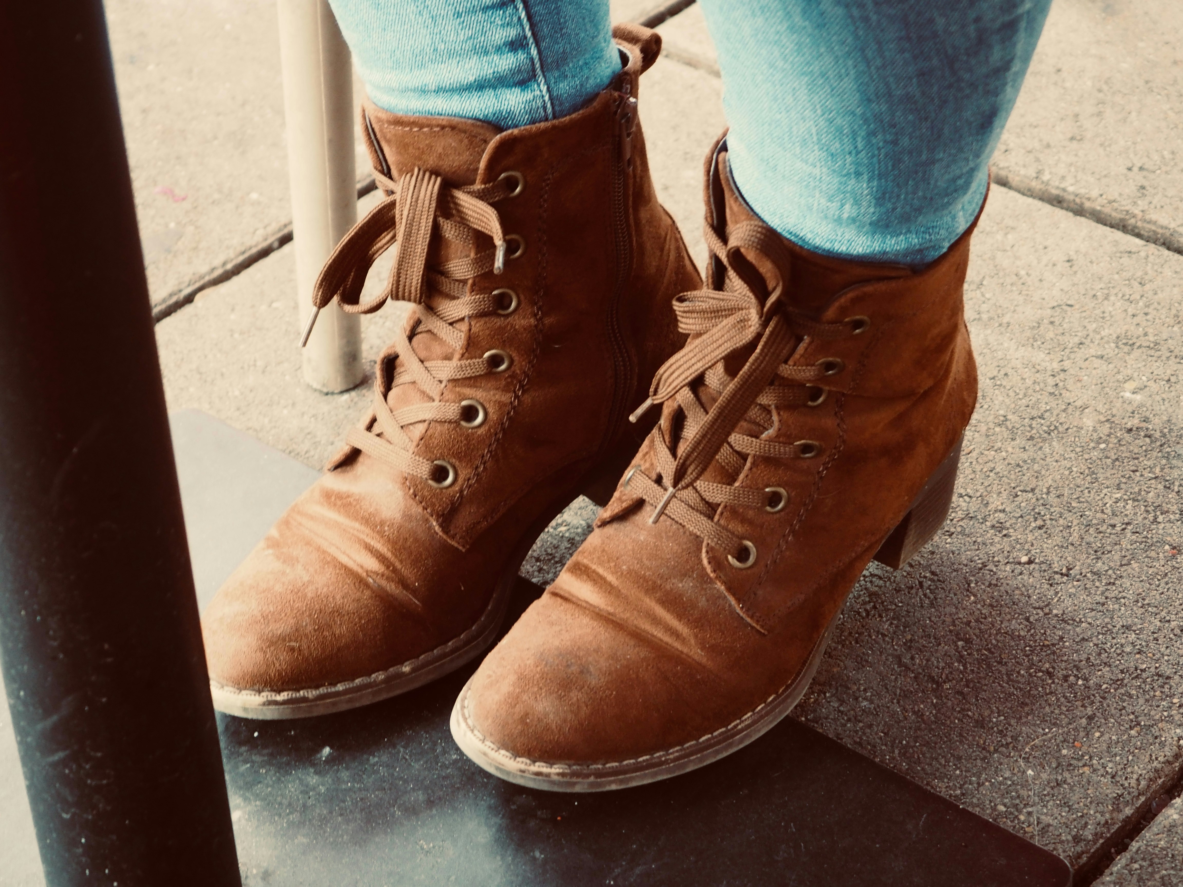 Botines con cordones de ante marrón con vaqueros