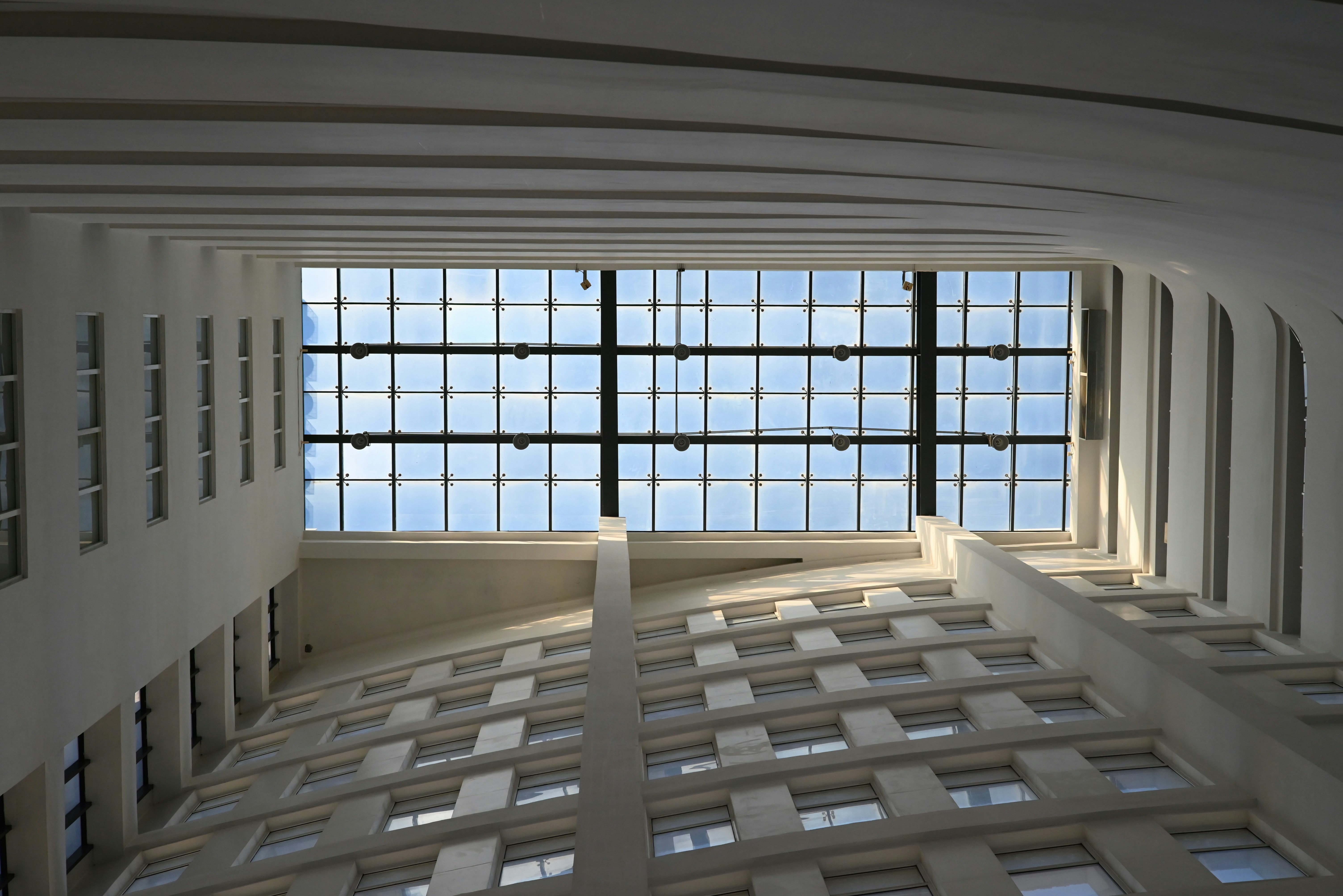 Interior de edificio moderno con techo de cristal y estructura de hormigón