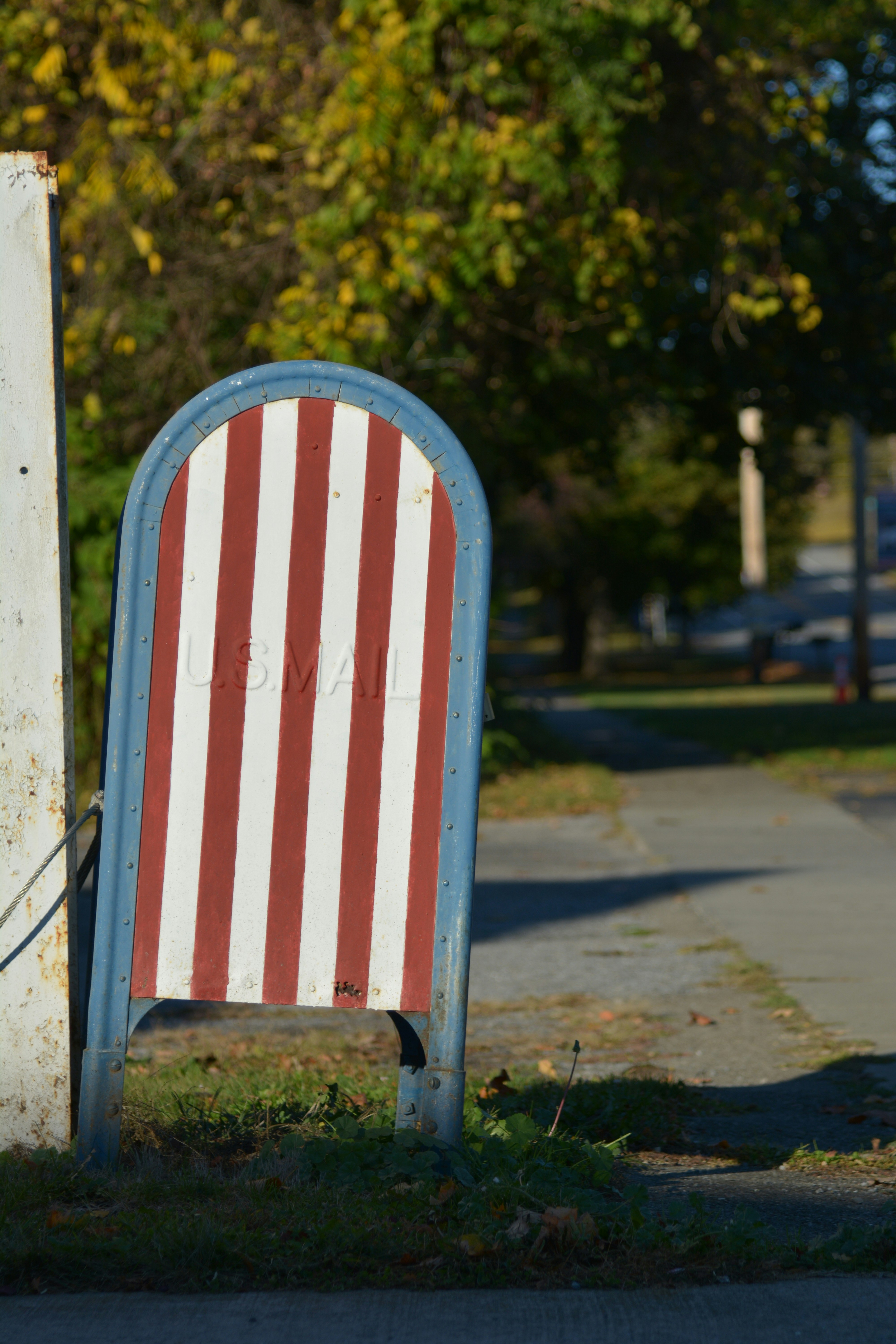 Red and white striped mailbox with blue trim