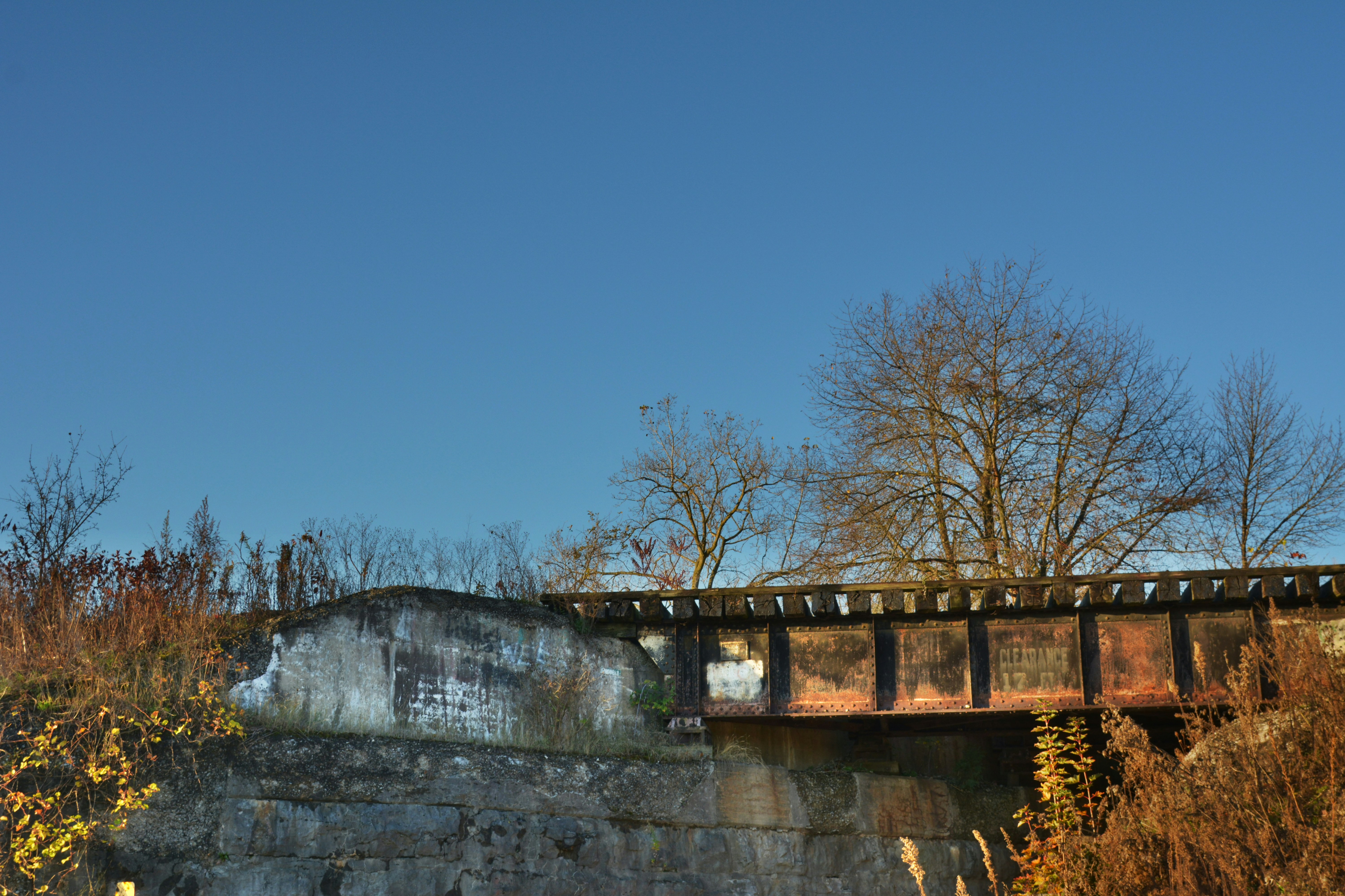Old railway bridge over a dry embankment under clear sky