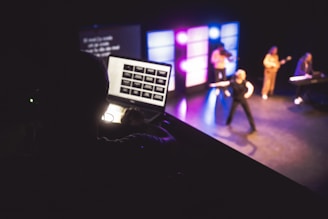 Musicians performing on stage with laptop control