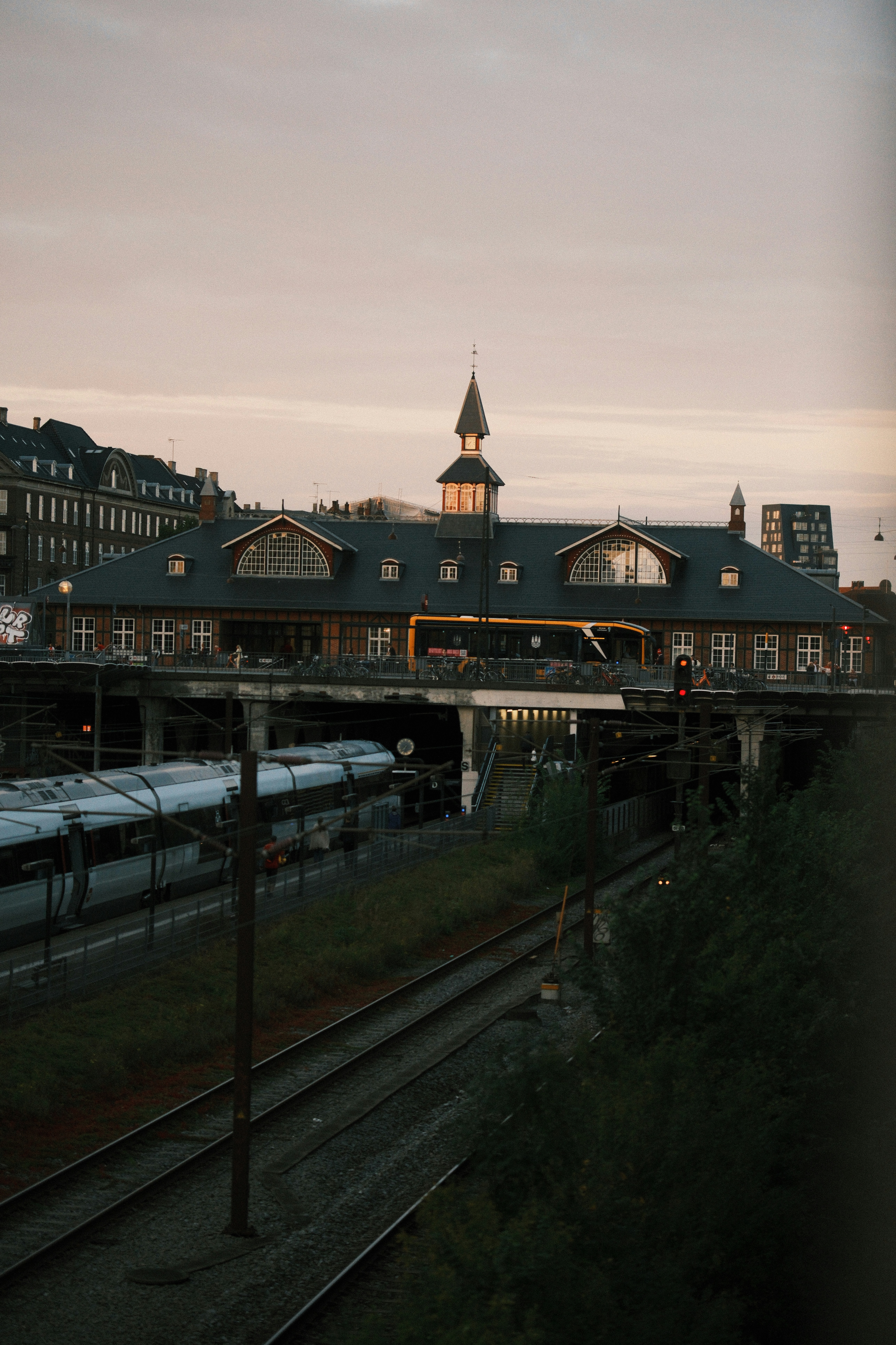Bâtiment de la gare avec des trains sur les rails au crépuscule