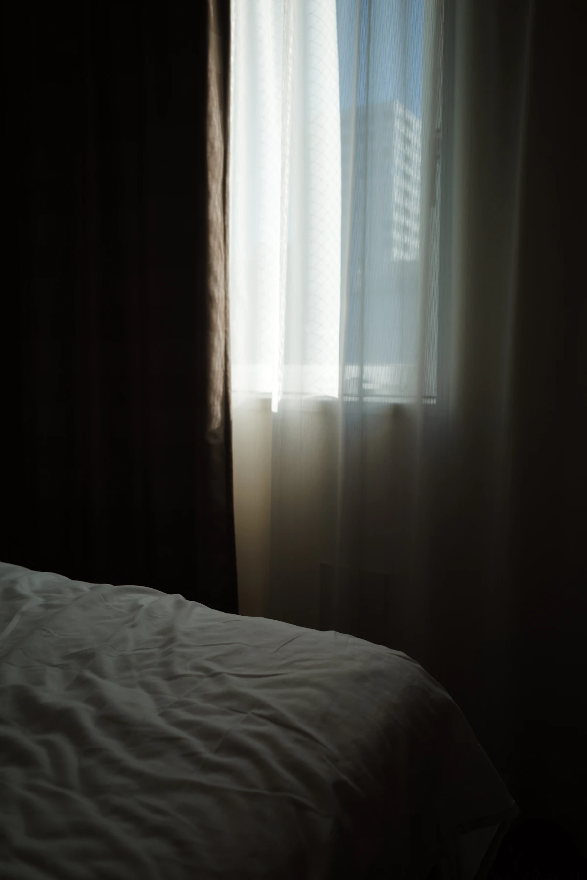 A bedroom at dawn, soft blue-to-warm light through the window.