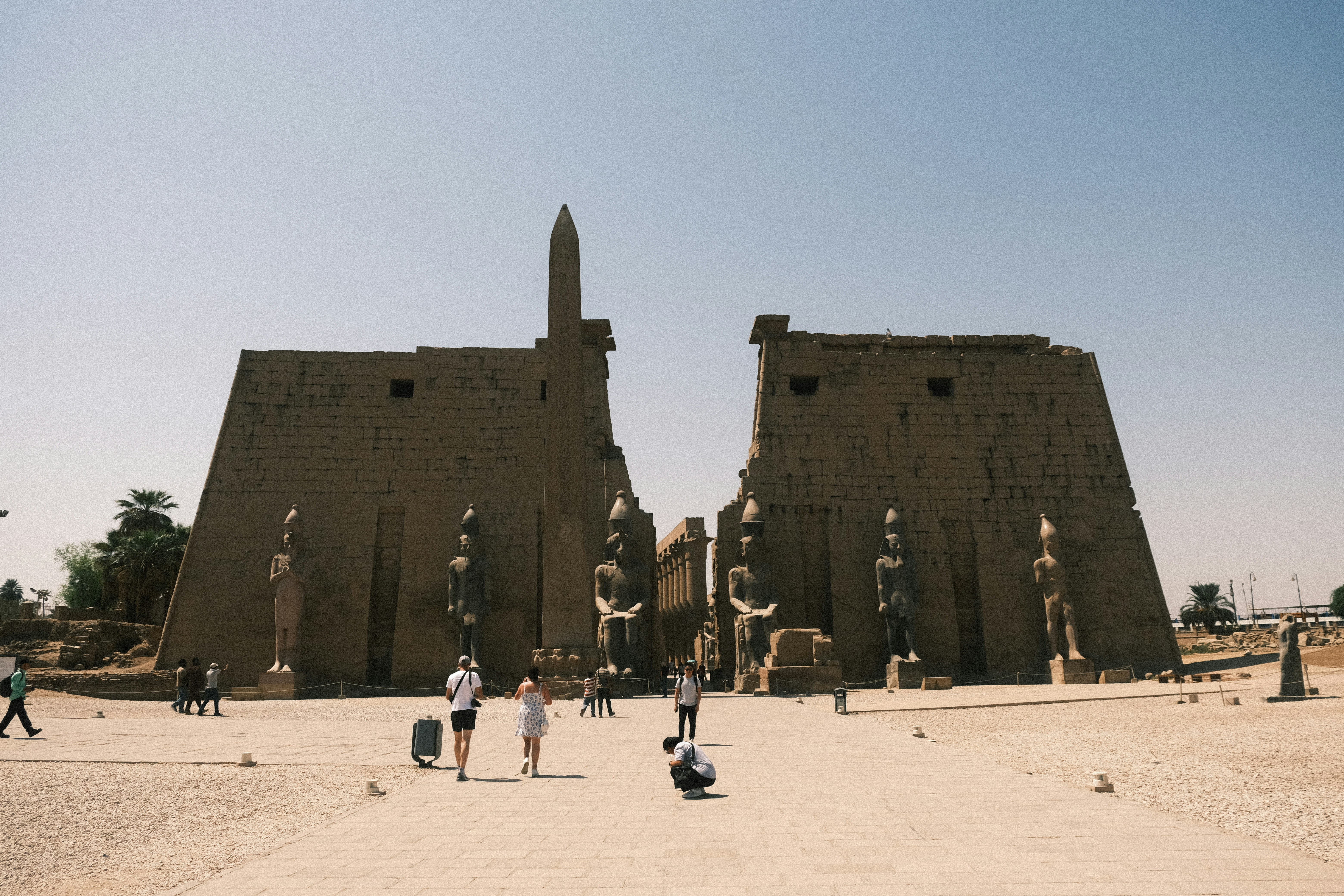 Ancient egyptian temple complex with statues and tourists