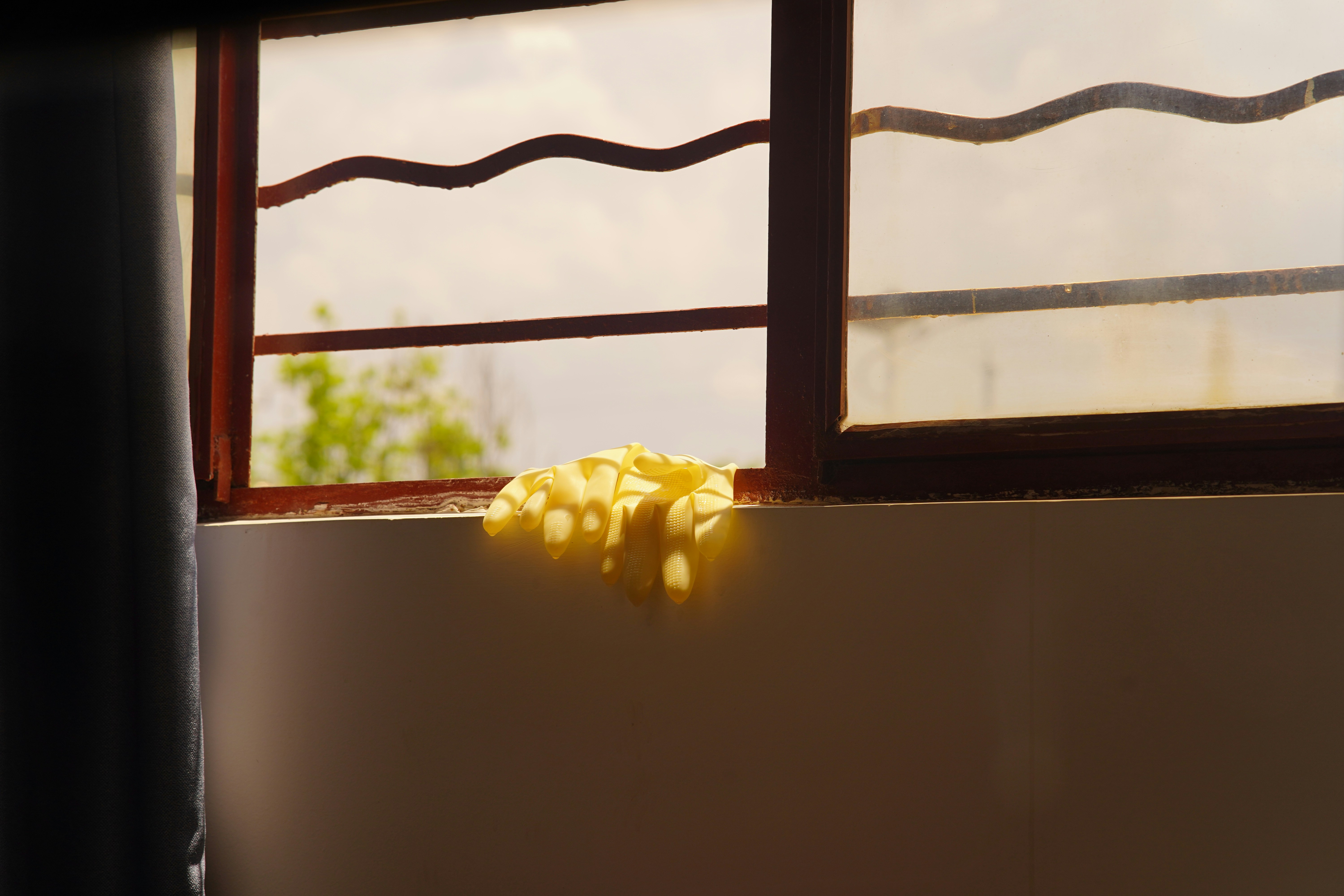 Esponja amarilla en el alféizar de una ventana cerca de la ventana