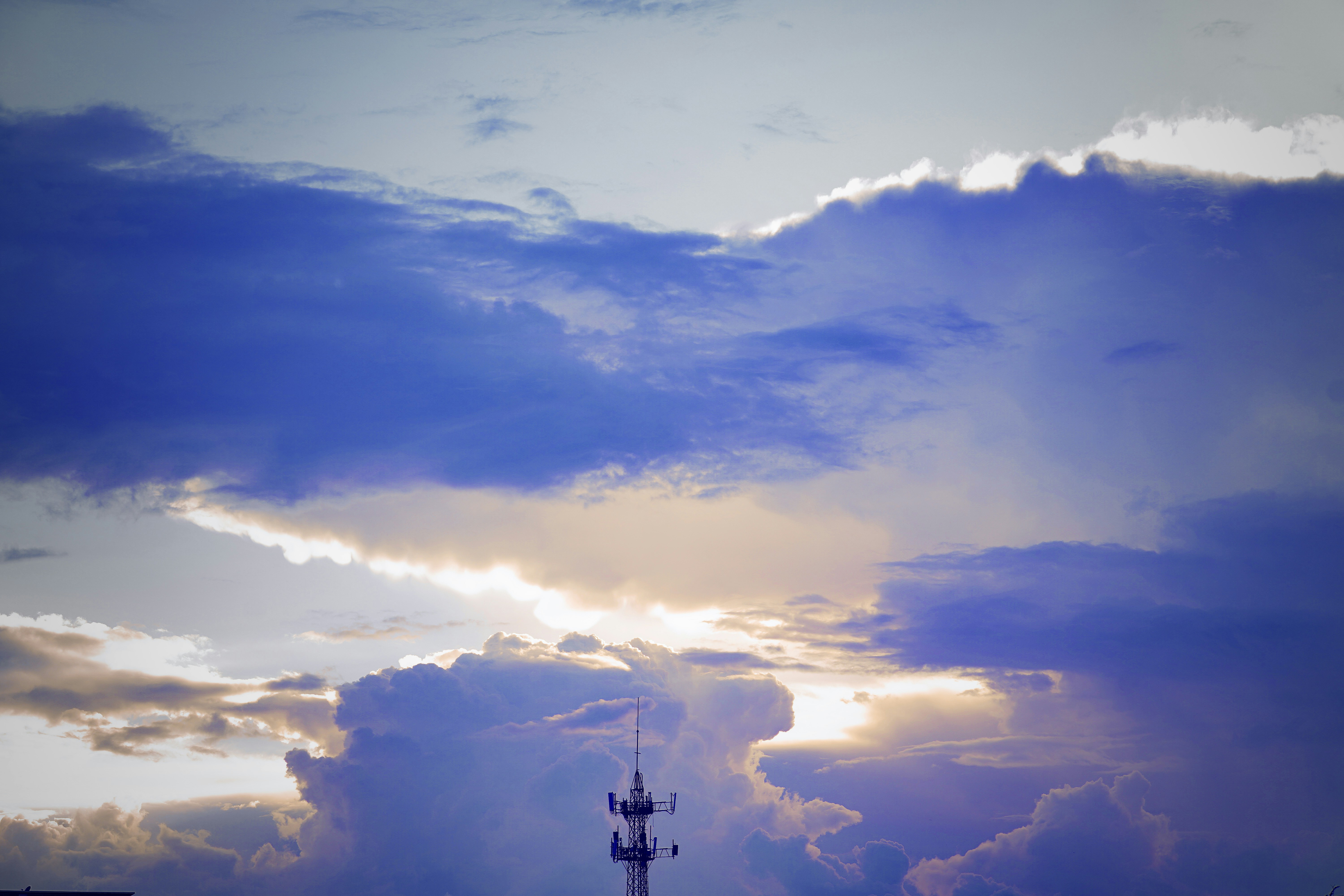 Tall tower silhouetted against dramatic stormy clouds