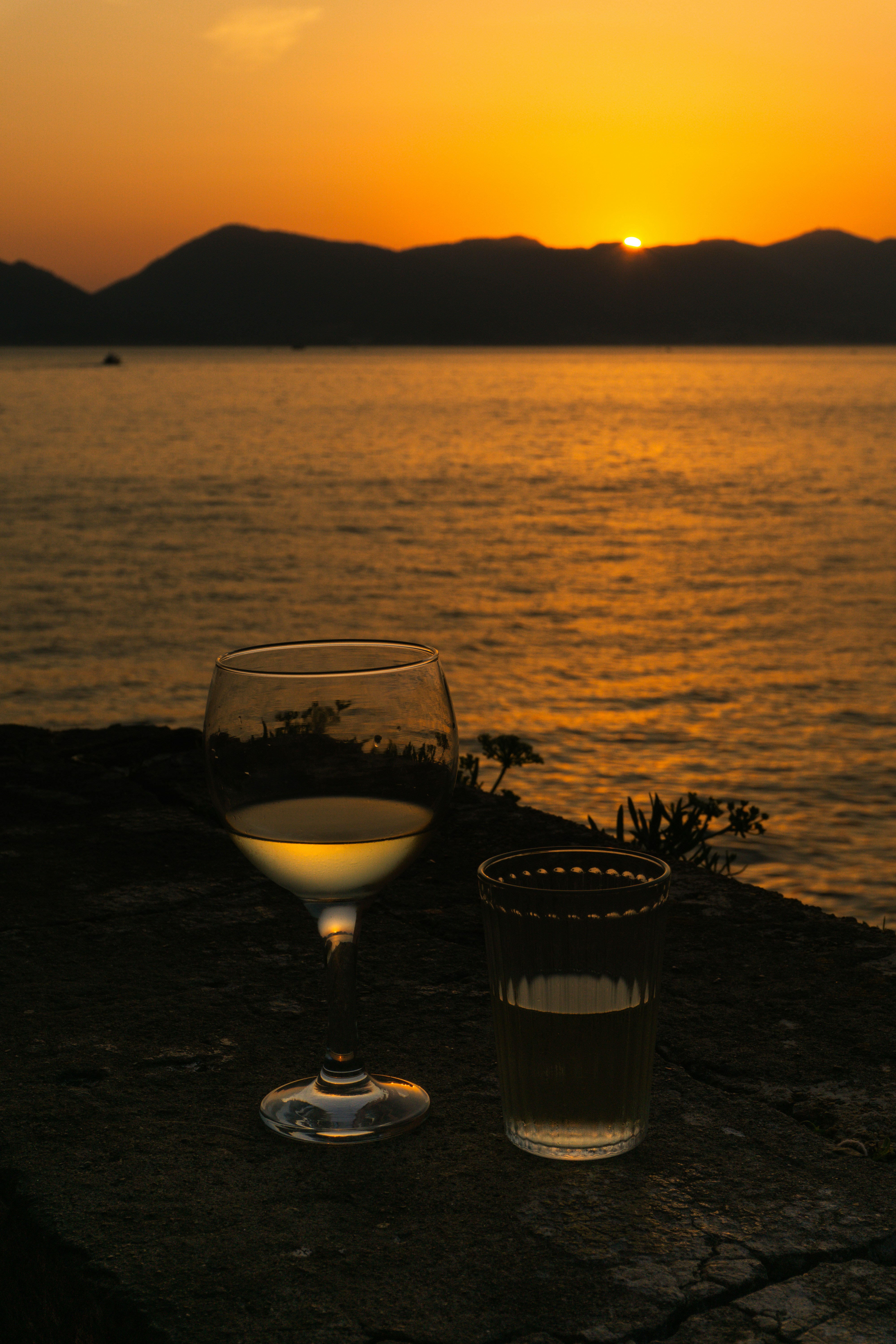 Two glasses of wine at sunset by the sea