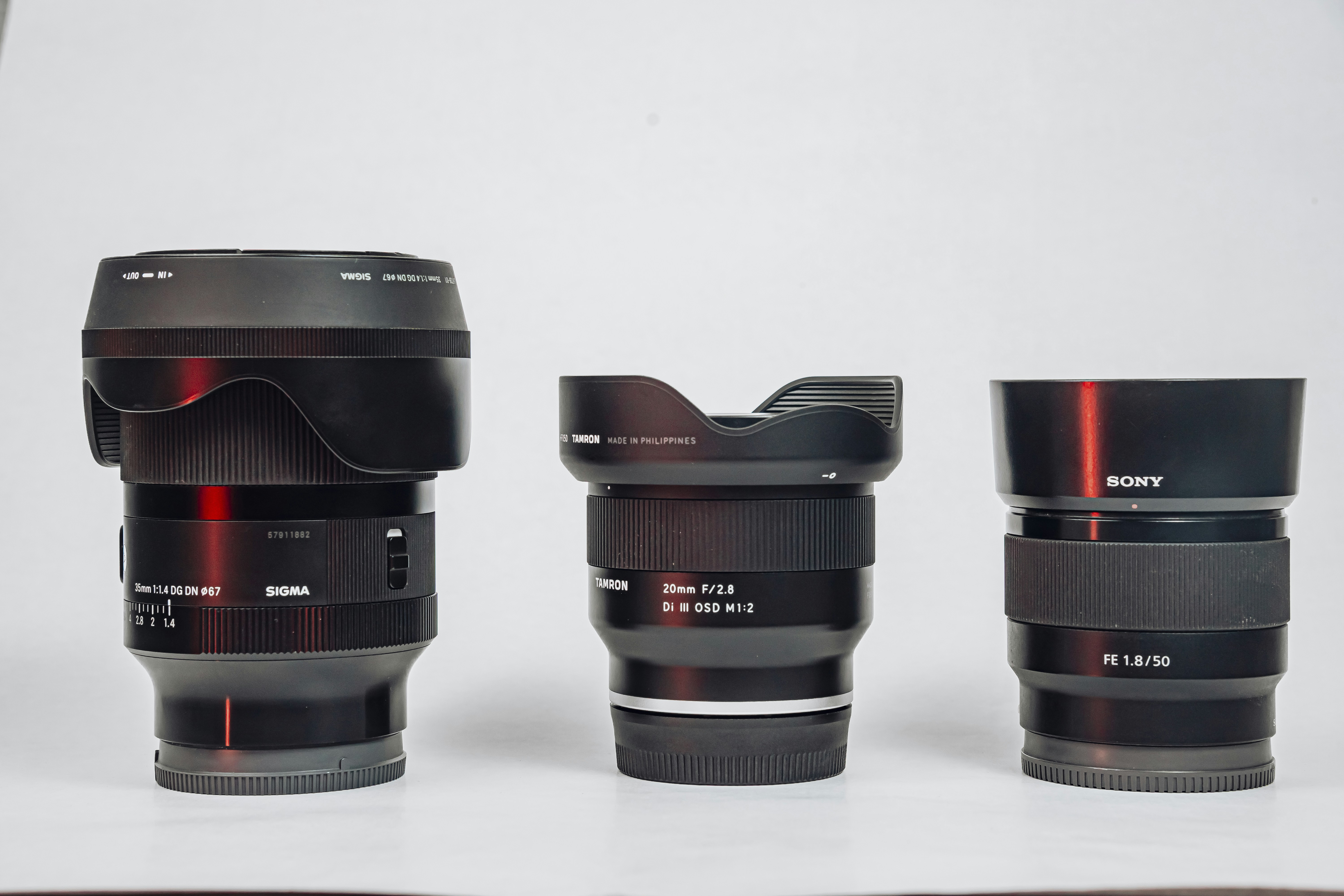 Three camera lenses lined up on a white background.
