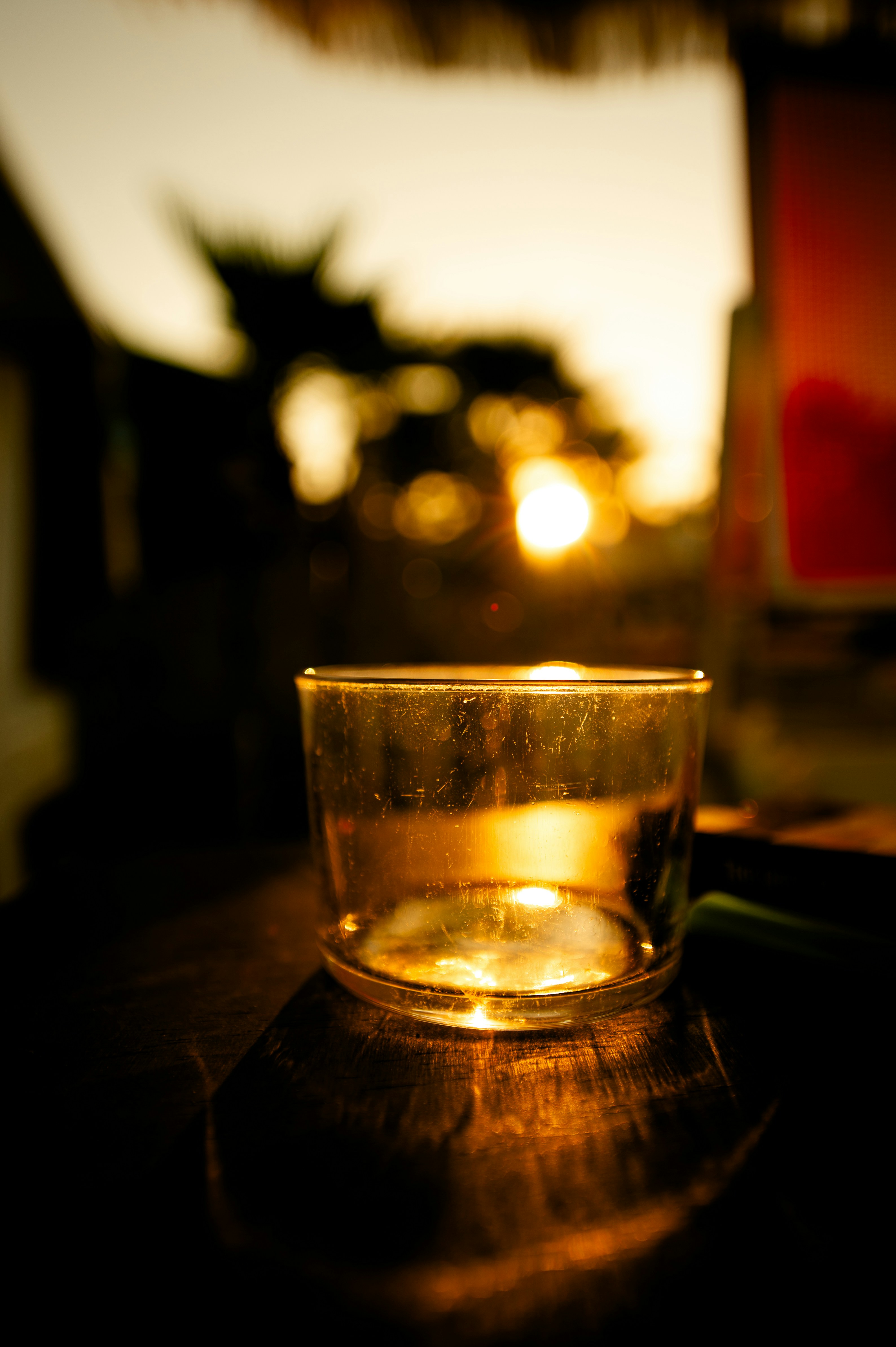 A glass of water reflects the sunset light.