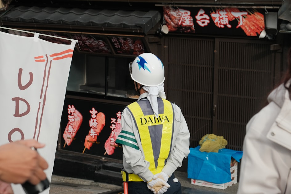 Worker in safety vest stands near food stall