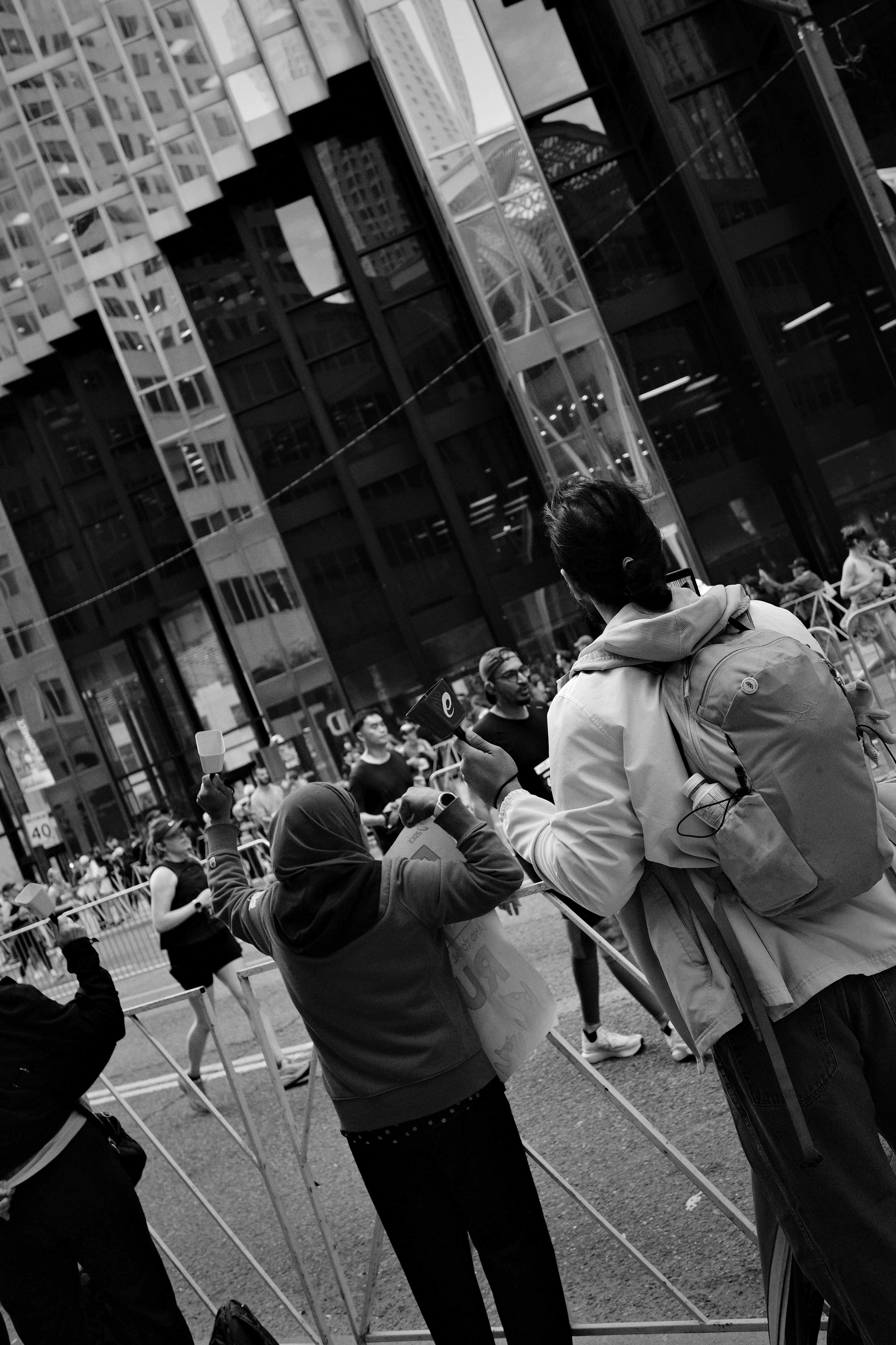 Gente viendo un evento callejero con edificios modernos