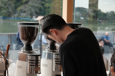Barista preparing coffee with grinders in-store grinders