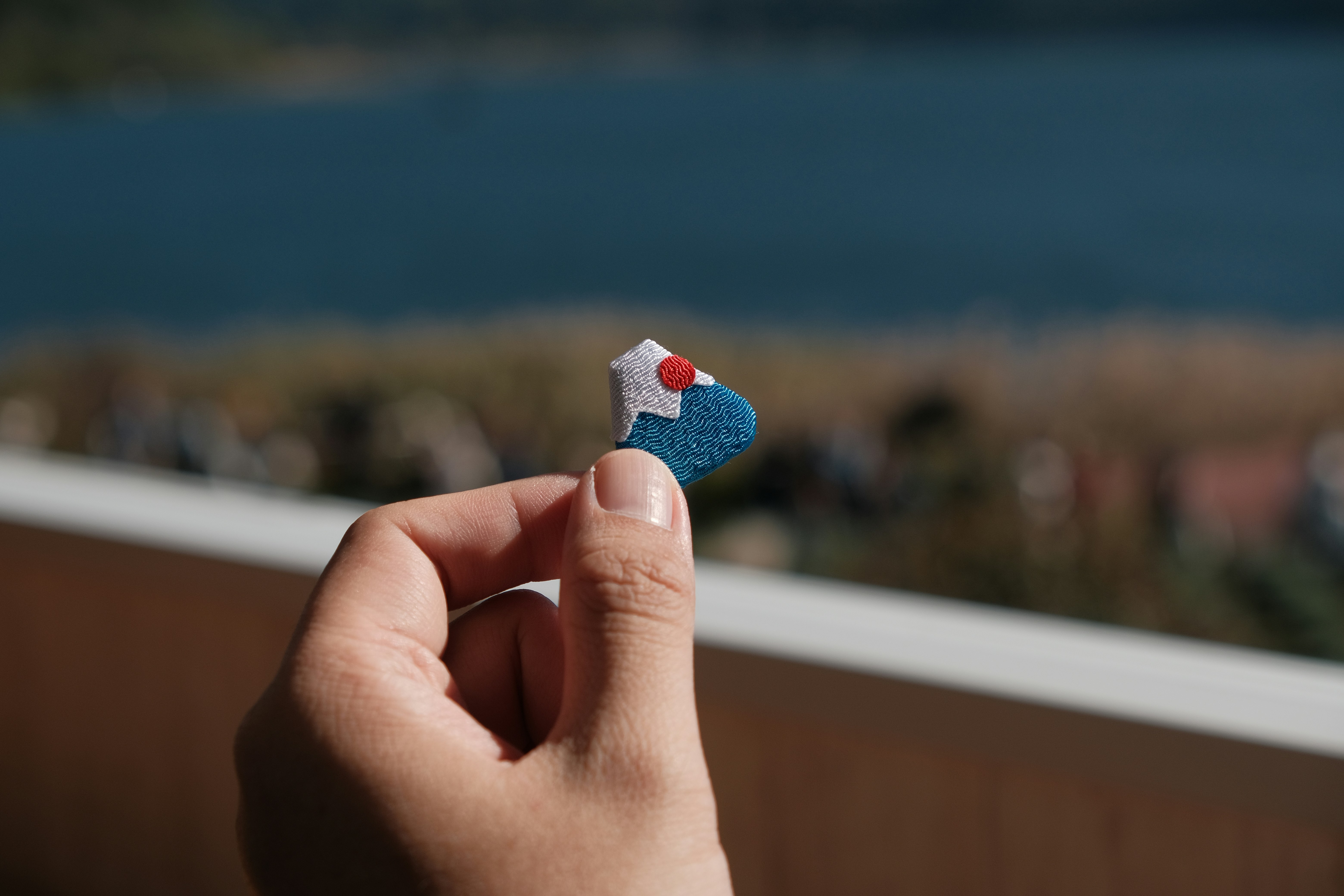 Hand holding a small mount fuji charm