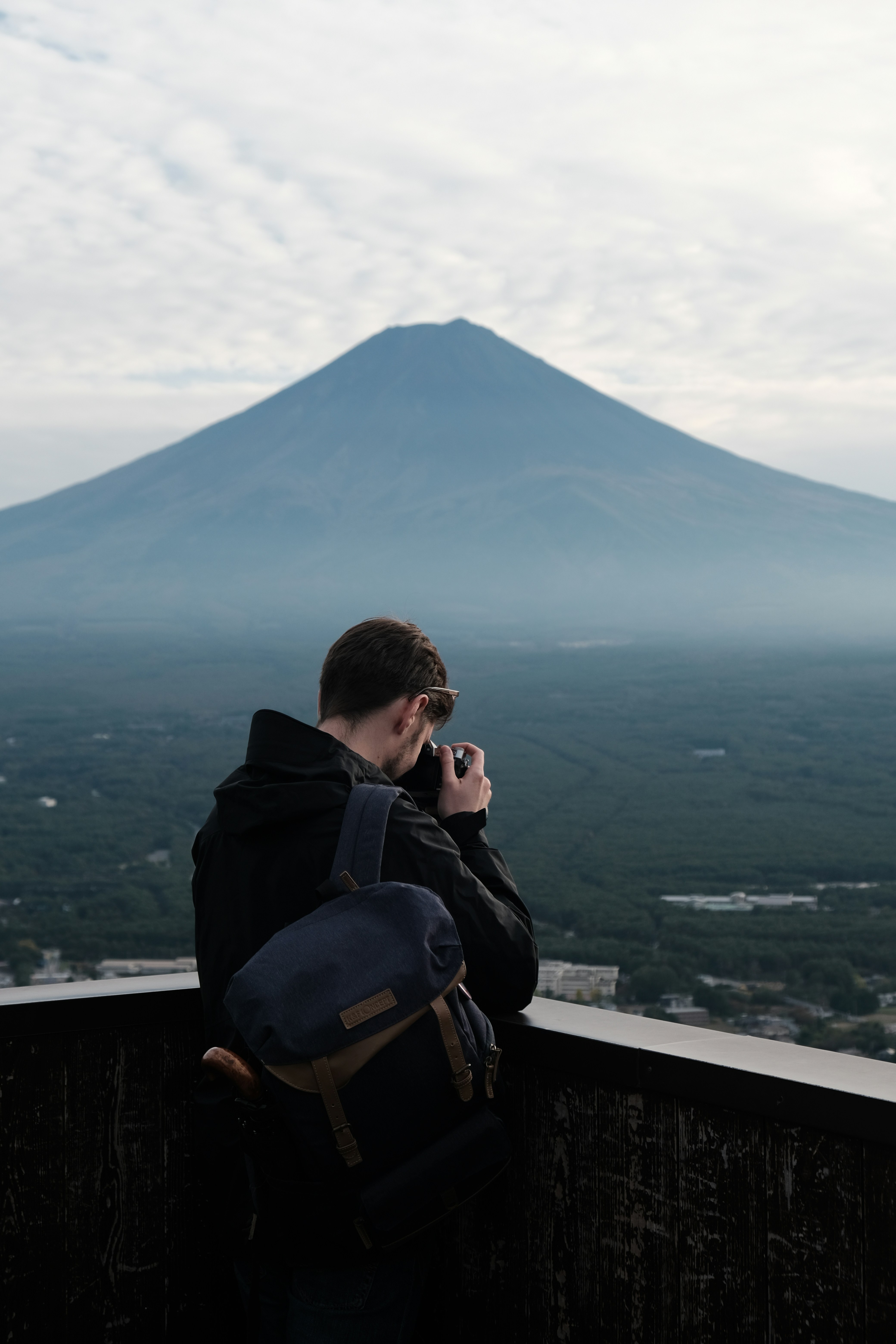 Man photographing a large mountain landscape.