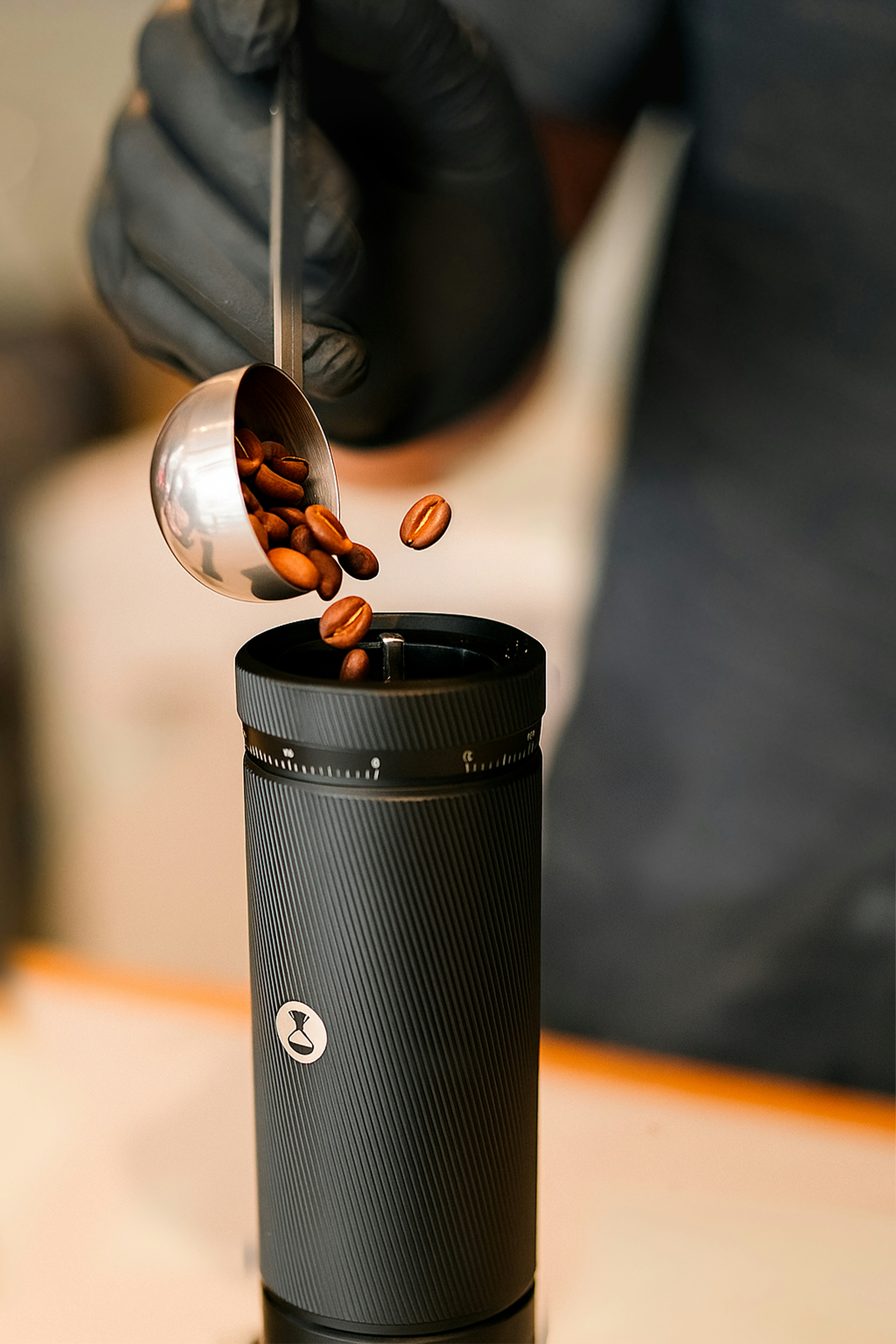 Barista pouring coffee beans into grinder