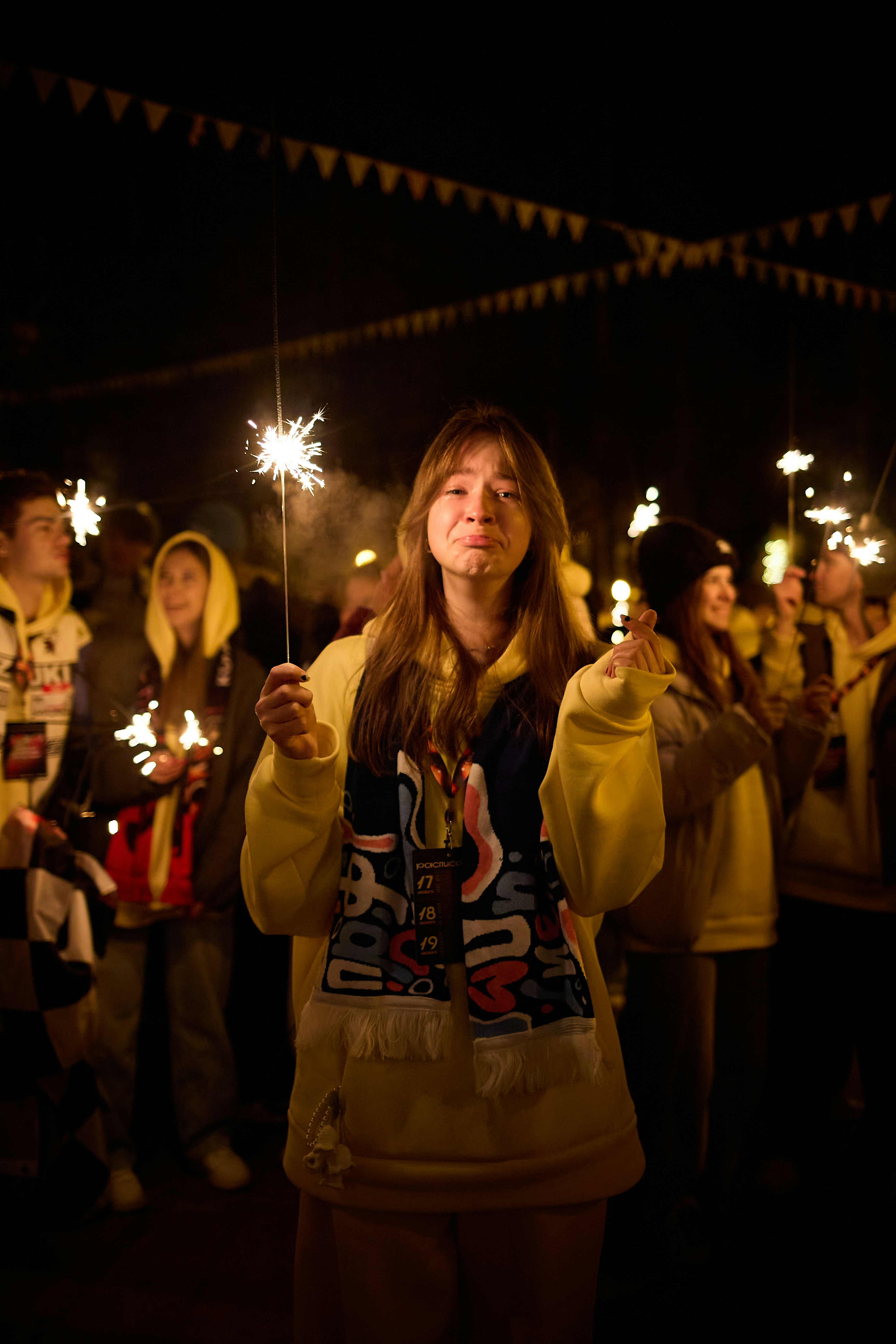 Young woman holding sparkler at night celebration
