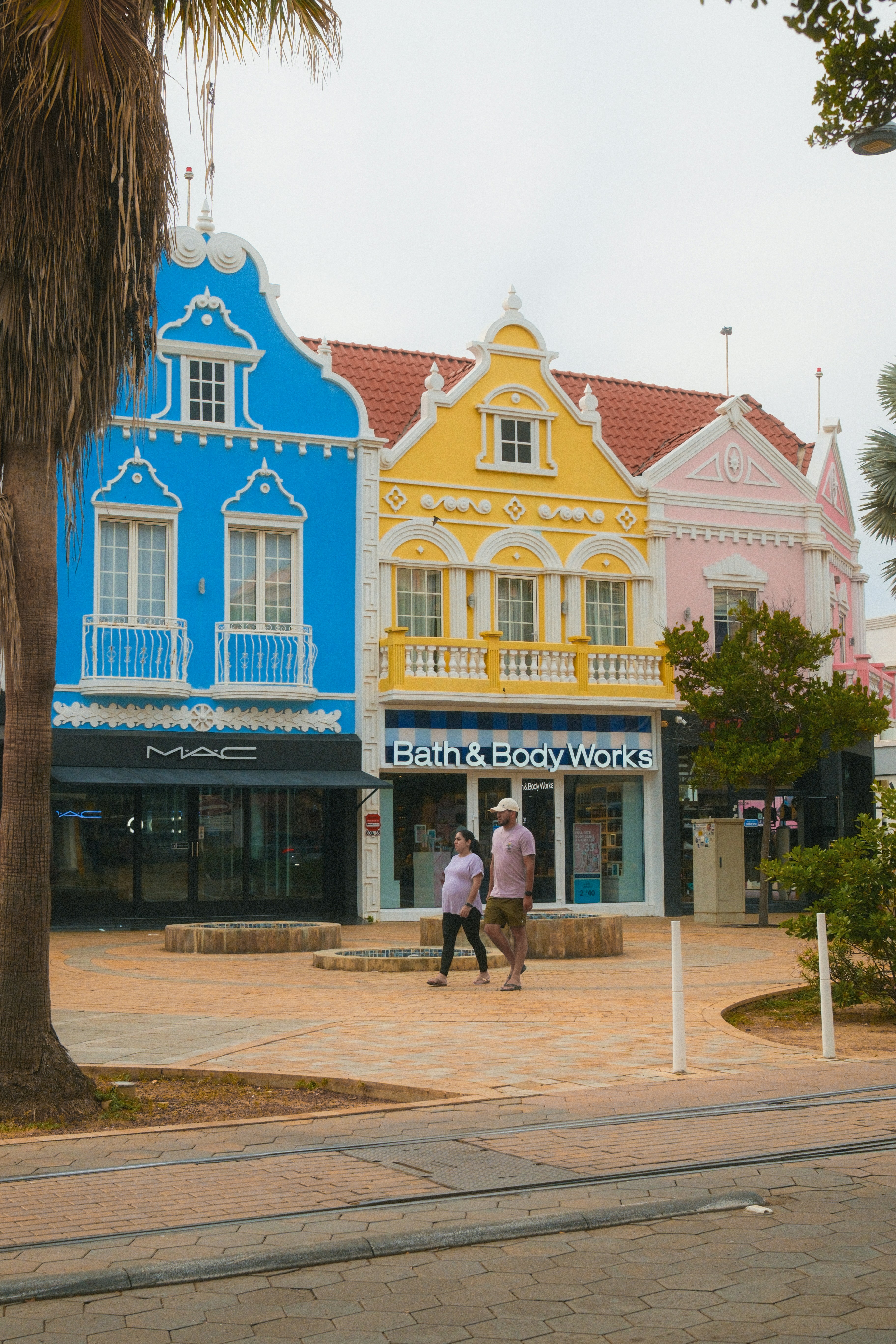 Des bâtiments colorés avec des boutiques et des gens qui se promènent.