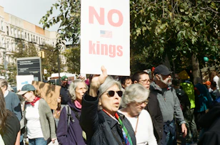 People protest with a "no kings" sign.