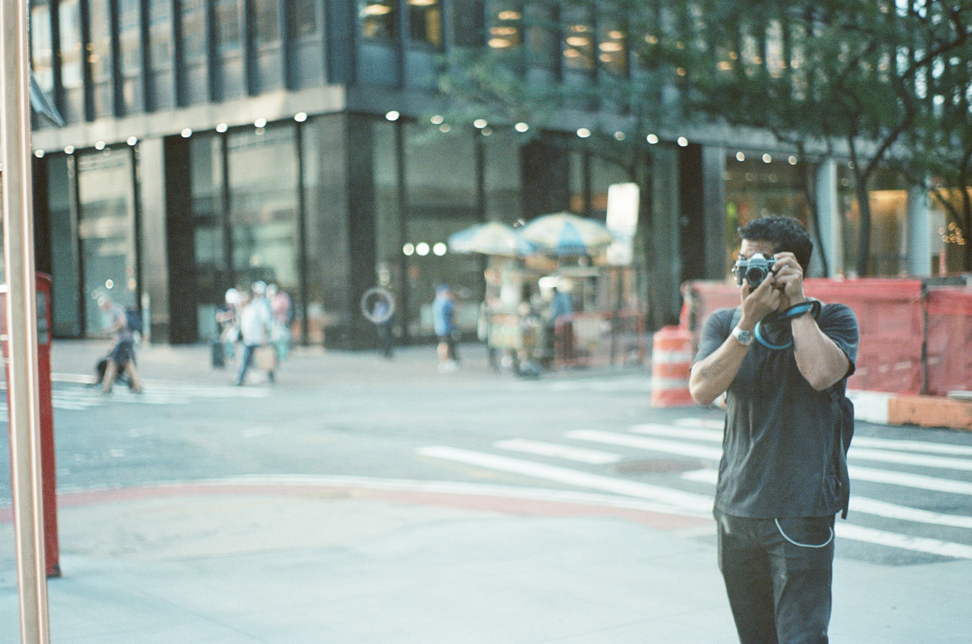 Man taking a picture with a camera in the city.
