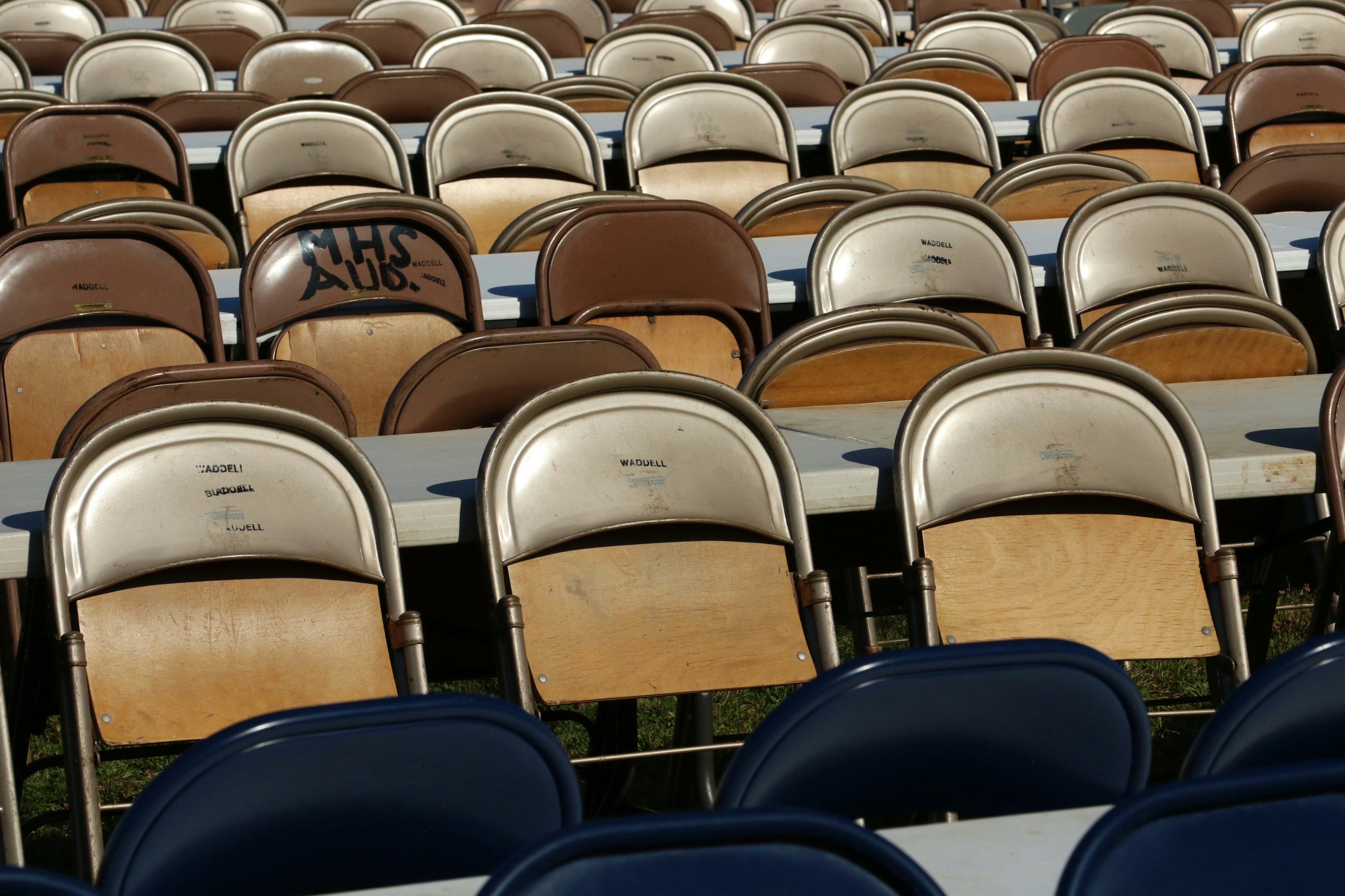 Rows of empty folding chairs at an outdoor venue