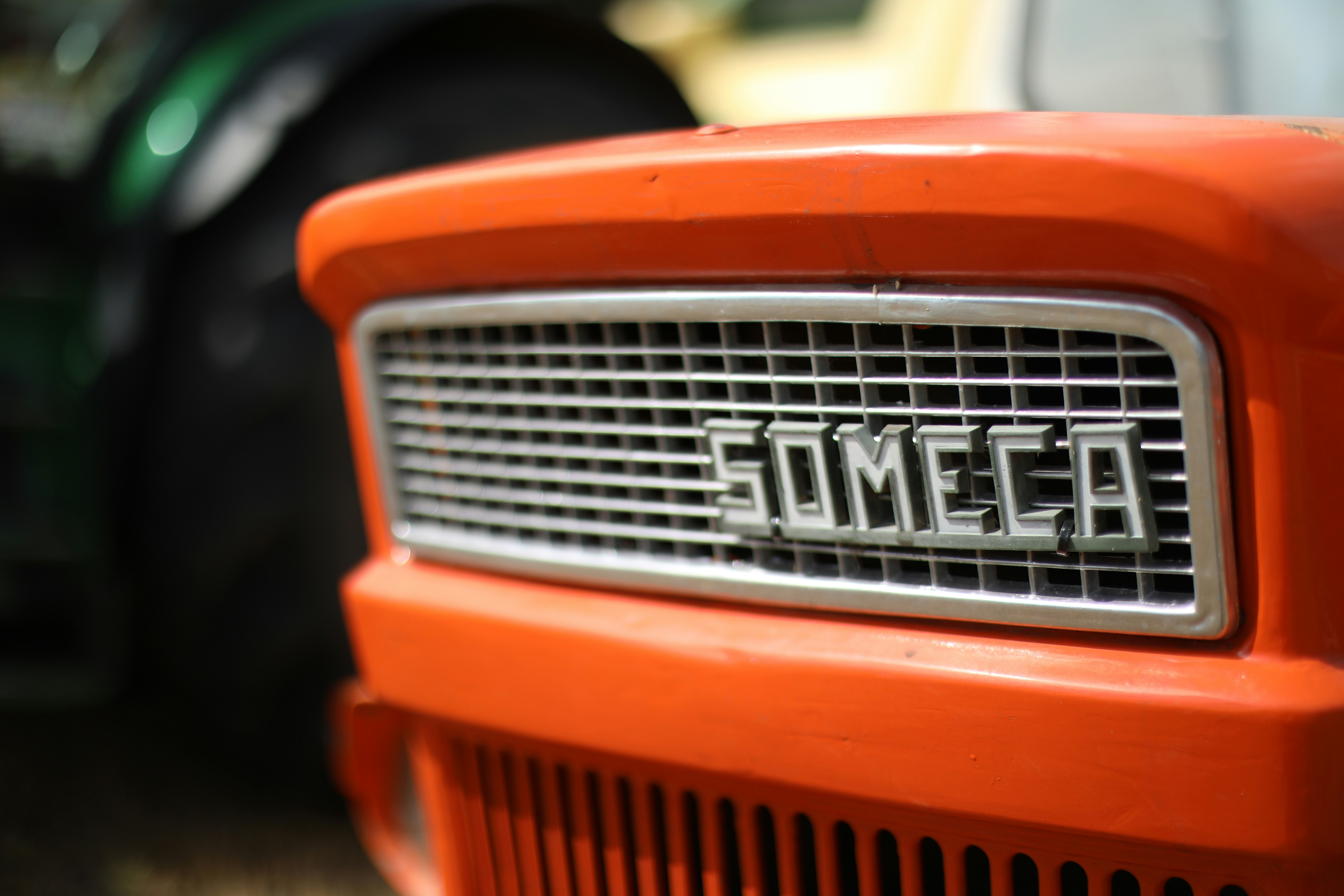 Orange tractor grille with someca logo