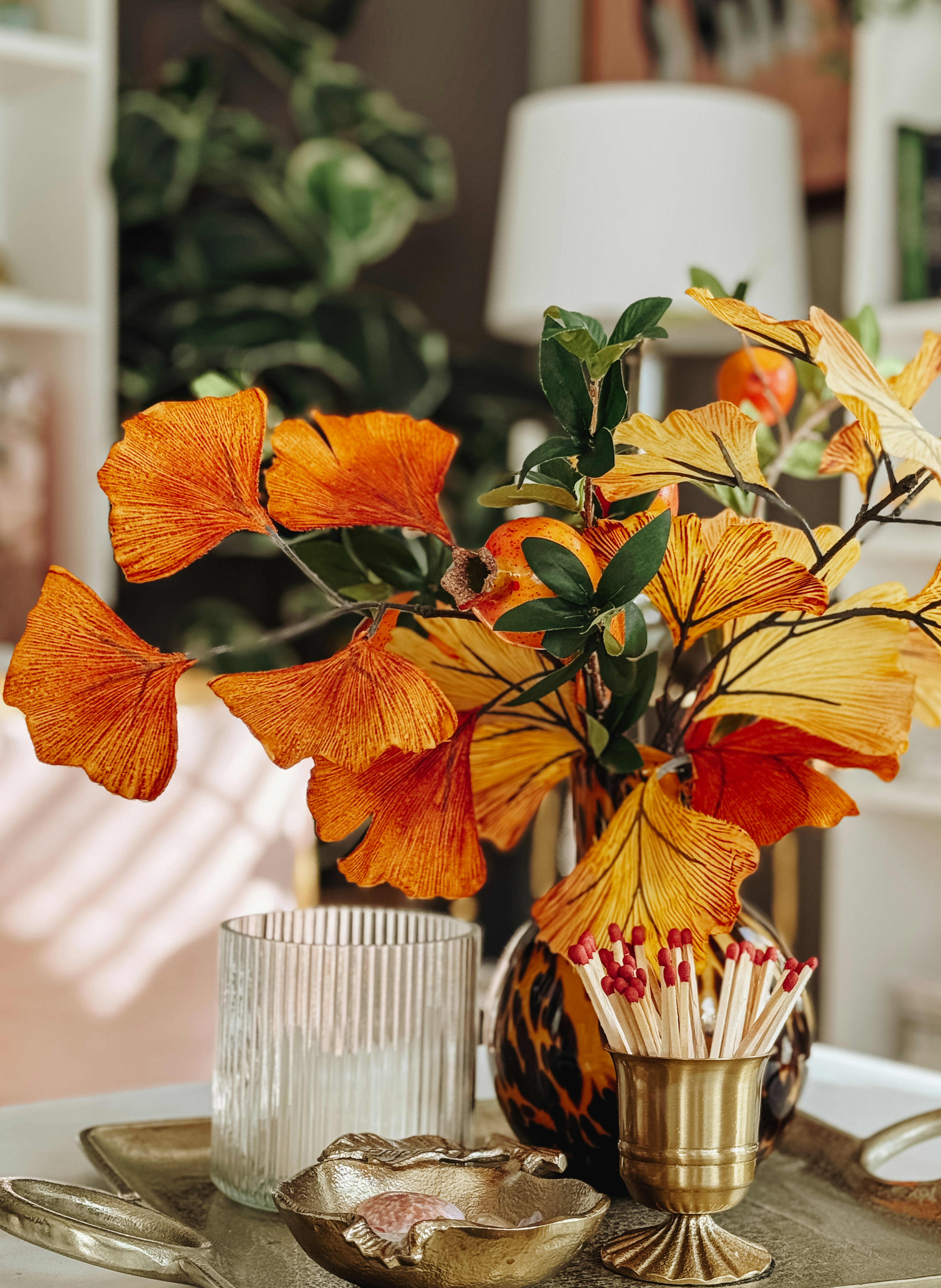 Folhas alaranjadas e amarelas em um vaso com fósforos