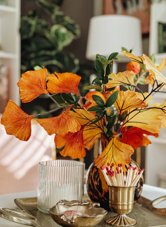 Orange and yellow leaves in a vase with matches