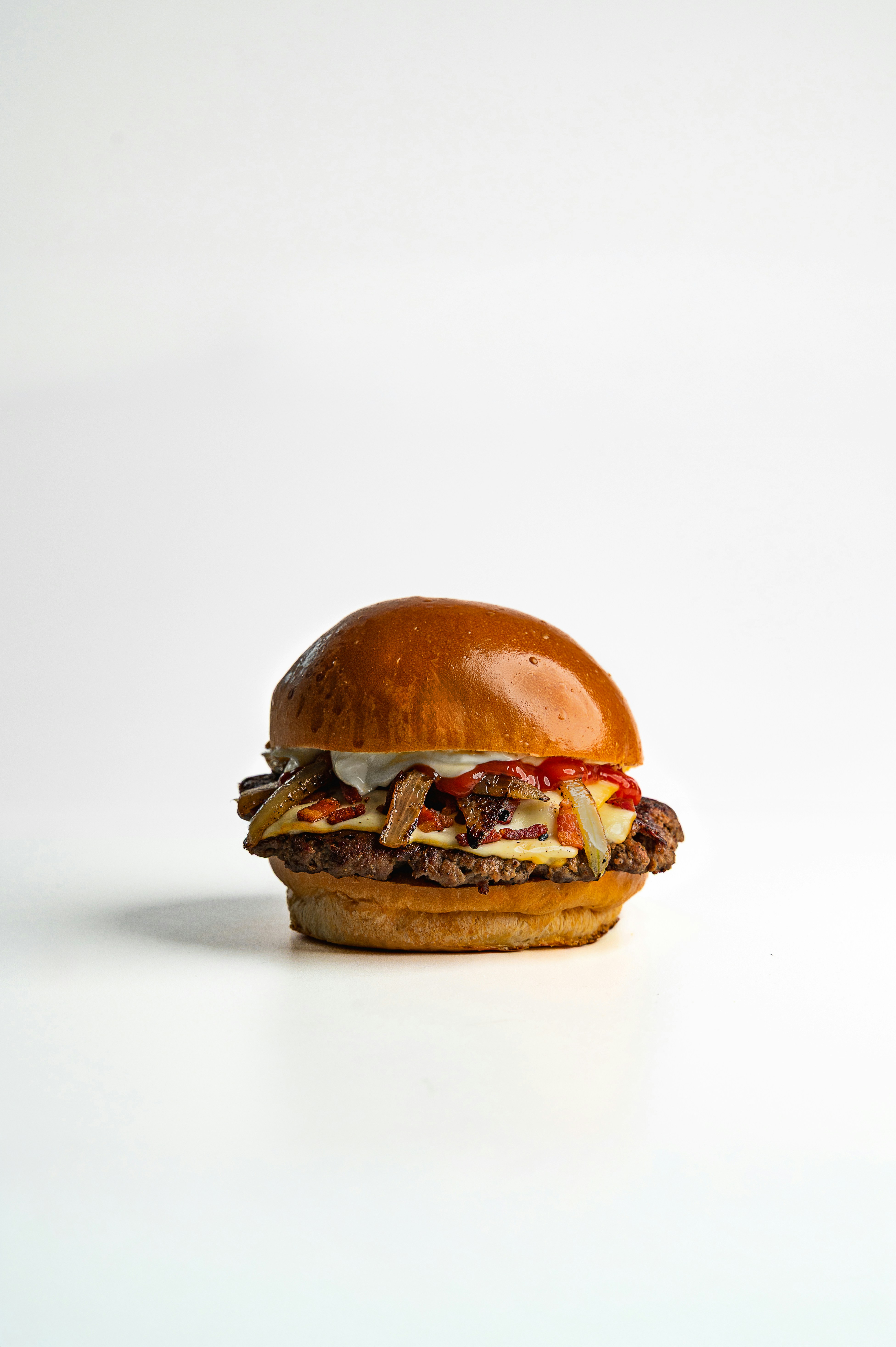 A juicy double cheeseburger with toppings on white background