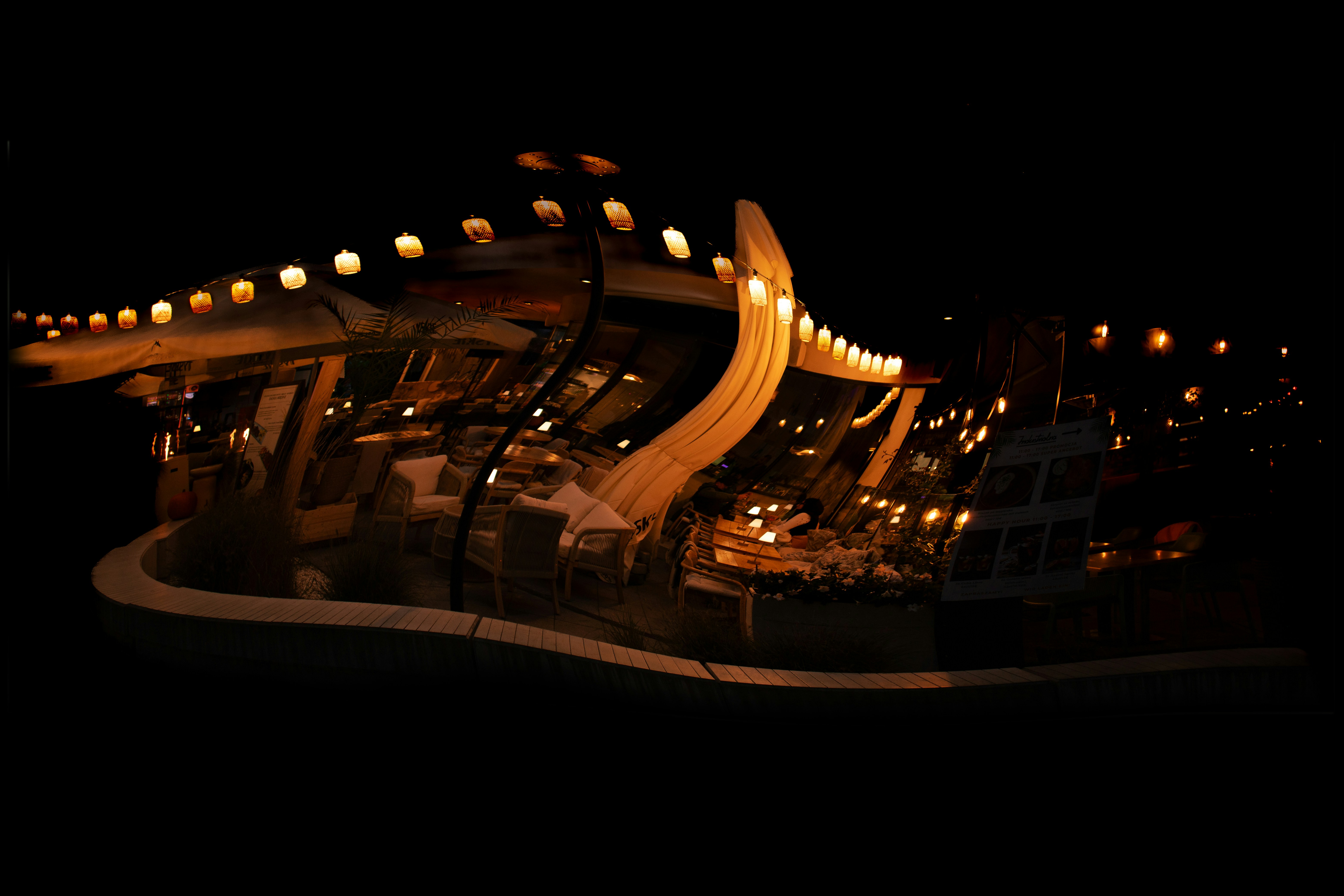 A restaurant illuminated by string lights at night