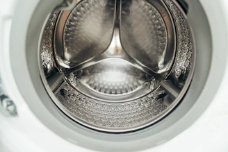 Inside view of a clean, empty washing machine drum.