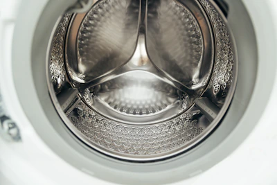 Inside view of a clean, empty washing machine drum.