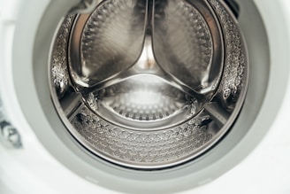 Inside view of a clean, empty washing machine drum.