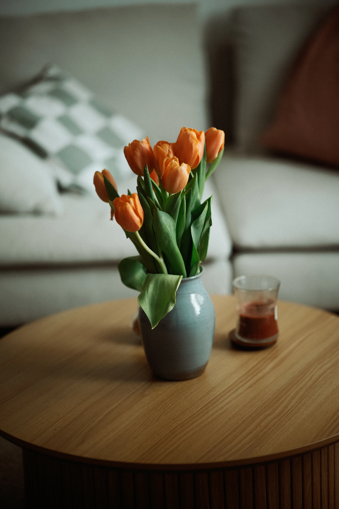 Oranje tulpen in een glazen vaas op een salontafel