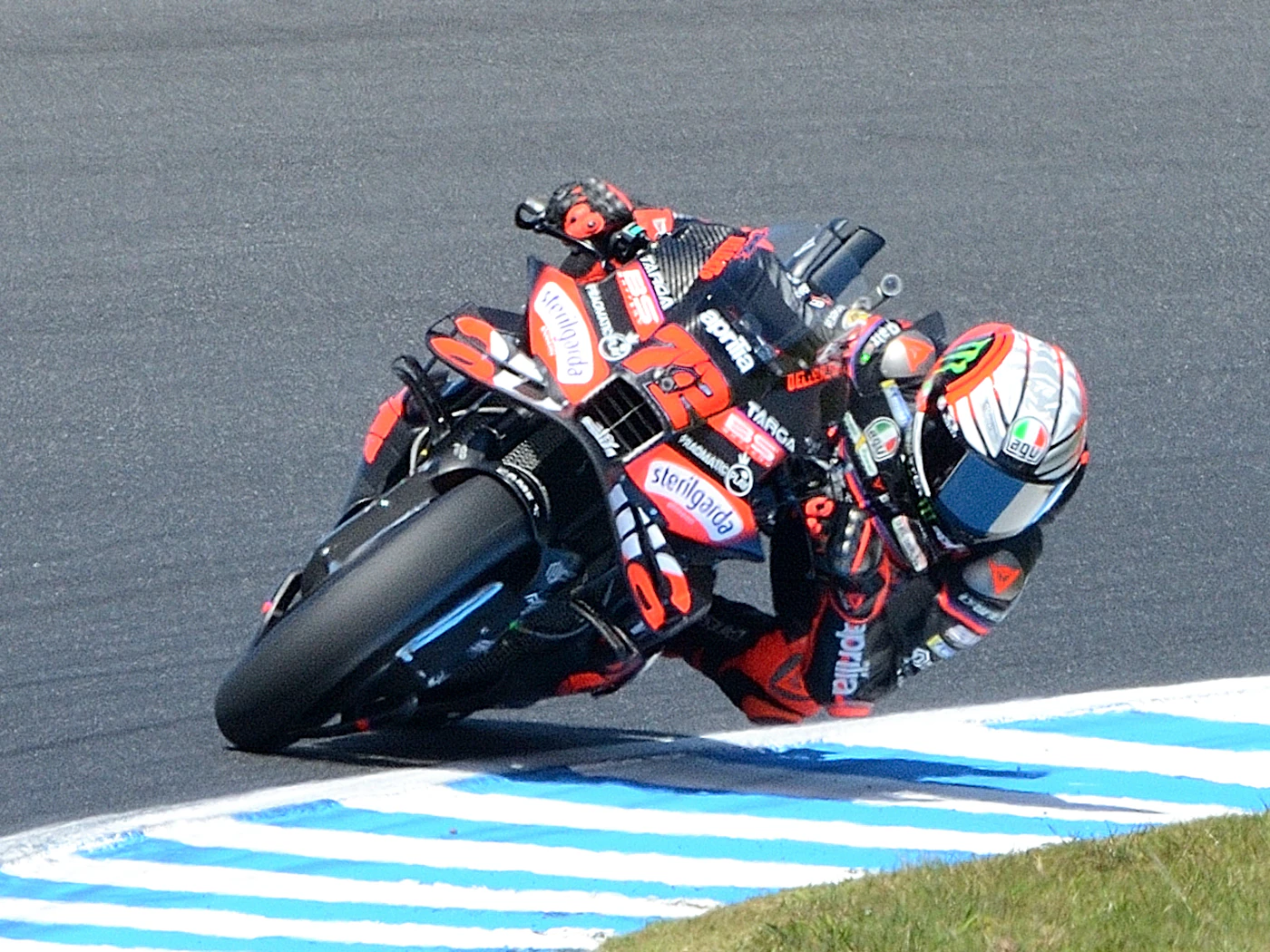 Motorcycle racer leaning into turn at MotoGP