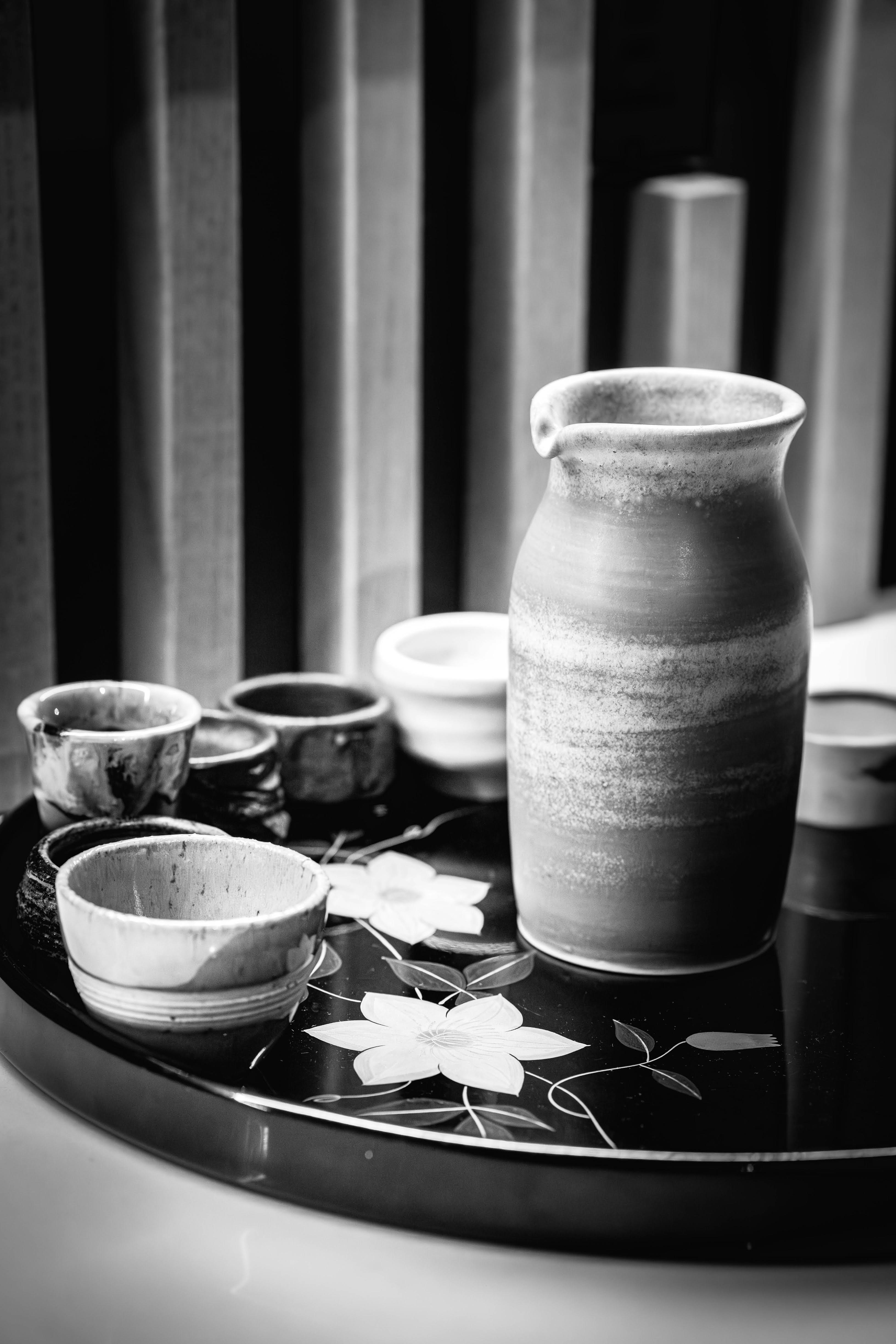 Sake set with ceramic cups and pitcher on tray.