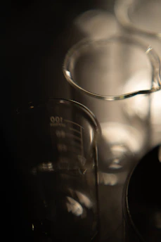 Several glass beakers on a dark background