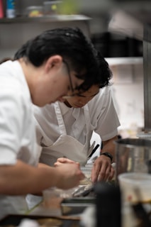 Two chefs preparing food in a kitchen.